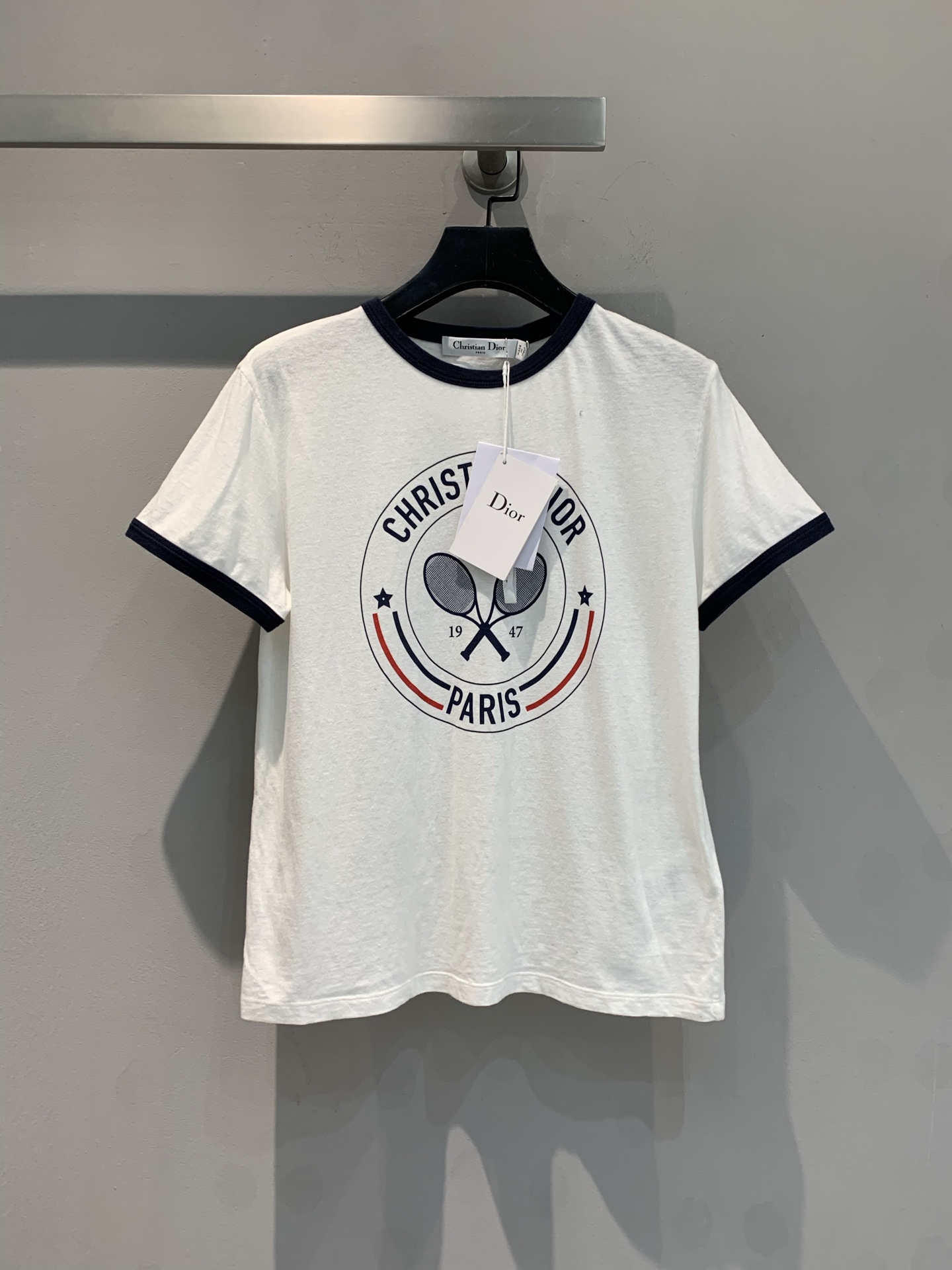 NO:327050,The new model is shipped. Original development CD2025 spring and summer new letter printing contrasting edge short-sleeved T-shirt, made of cotton and linen blended fabric. The texture is excellent and the style is crisp. The dark blue contrasting edges of the cuffs and neckline break the monotony and add a sense of layering and design. The crossed tennis racket elements on the chest are full of vitality. 