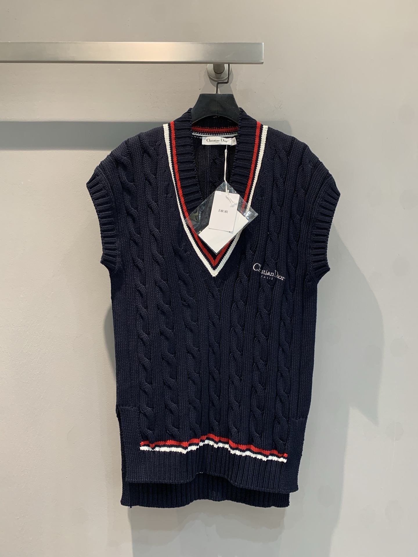 NO:332575,New model is shipped. Original real shot. CD2025 early spring new tennis style V-neck contrasting knitted vest. The dark blue body is matched with classic rope weaving texture, full of texture. The red and white stripes at the neckline and hem add details and highlights and liveliness. The V-neck design modifies the neckline, and the sleeveless style is suitable for a variety of inner wear. Whether it is matched with a shirt to create a business and casual style or a T-shirt to create a daily casual style, it can add layering and fashion to the outfit in autumn, showing elegant style. Number of codes 36 38 40,,shirts,tees,t-shirt,alexander wang19860909新款出货啦 原版实拍 CD2025早春新款网球风大V领撞色针织马甲.深蓝色主体搭配经典绞花编织纹理,质感十足.领口、下摆处红白色条纹装饰,增添细节亮点与活泼感.V领设计修饰颈部线条,无袖款式适配多种内搭,无论是搭配衬衫打造商务休闲风,还是搭配T恤营造日常随性风,都能在秋季为穿搭增添层次感与时尚度 ,尽显优雅格调.码数36 38 40,,shirts,tees，t-shirt,alexander wang,Women's clothing