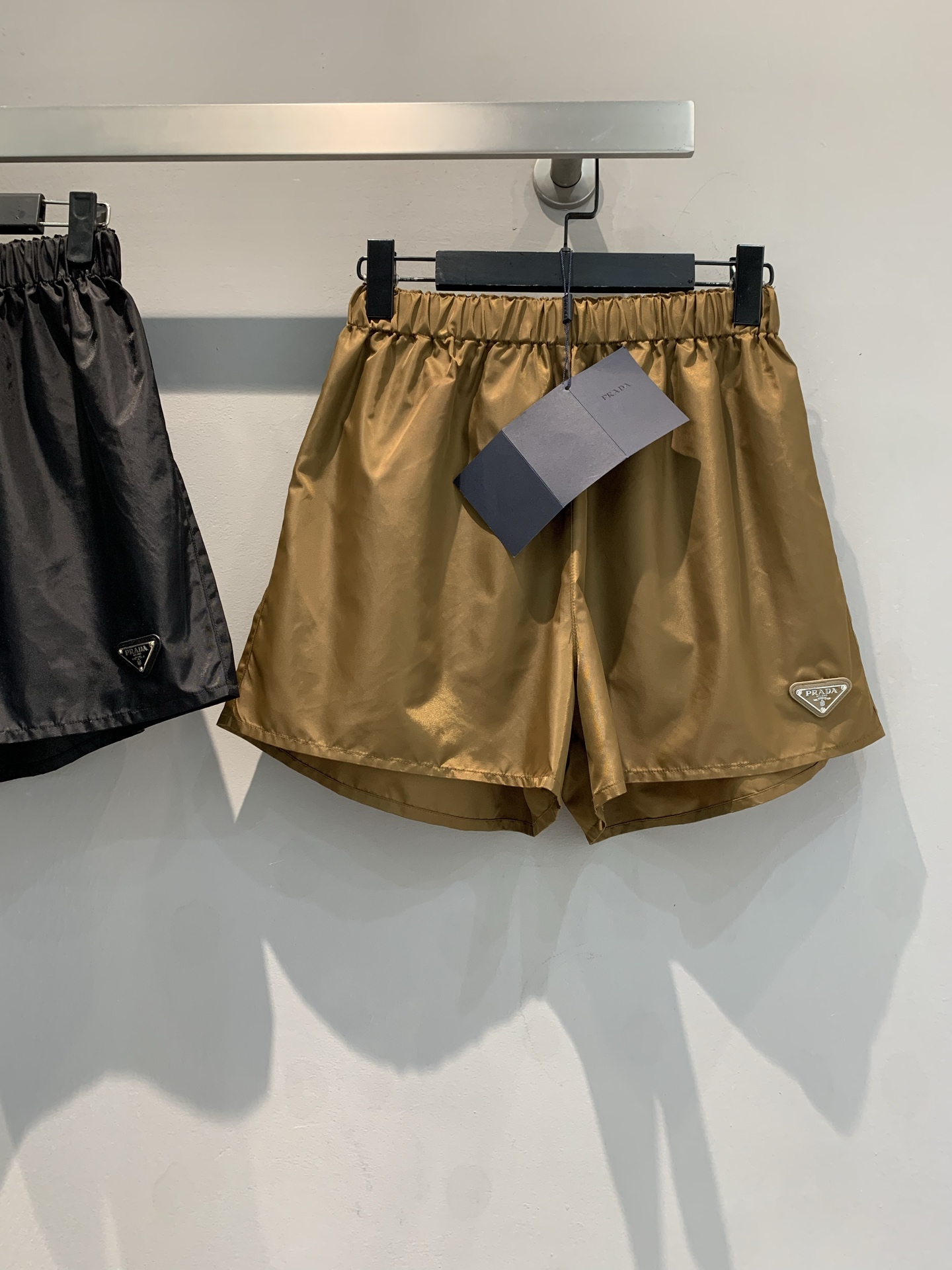 NO:327099,The new model shipped out original development Prad*2025 spring and summer new drawstring waist-shaped casual shorts. It uses recycled nylon fabric. It is breathable and skin-friendly, and the elastic waist design brings a free experience. The iconic triangle logo is exquisitely embellished, highlighting the brand style. Whether it is paired with a simple T-shirt or a fashionable top to attend an event, it can easily control different styles and exude unique charm. SML, prada, shorts, tees, t-shirt, alexander wang19860909新款出货啦原版开发 Prad*2025春夏新款抽绳塑腰休闲短裤.采用再生尼龙面料.透气亲肤,松紧腰设计带来自在体验.标志性三角徽标精致点缀,彰显品牌格调.无论是搭配简约T恤出街,还是配上时尚上衣出席活动,都能让你轻松驾驭不同风格,绽放独特魅力.码数SML,,prada,shorts,tees，t-shirt,alexander wang,Women's clothing