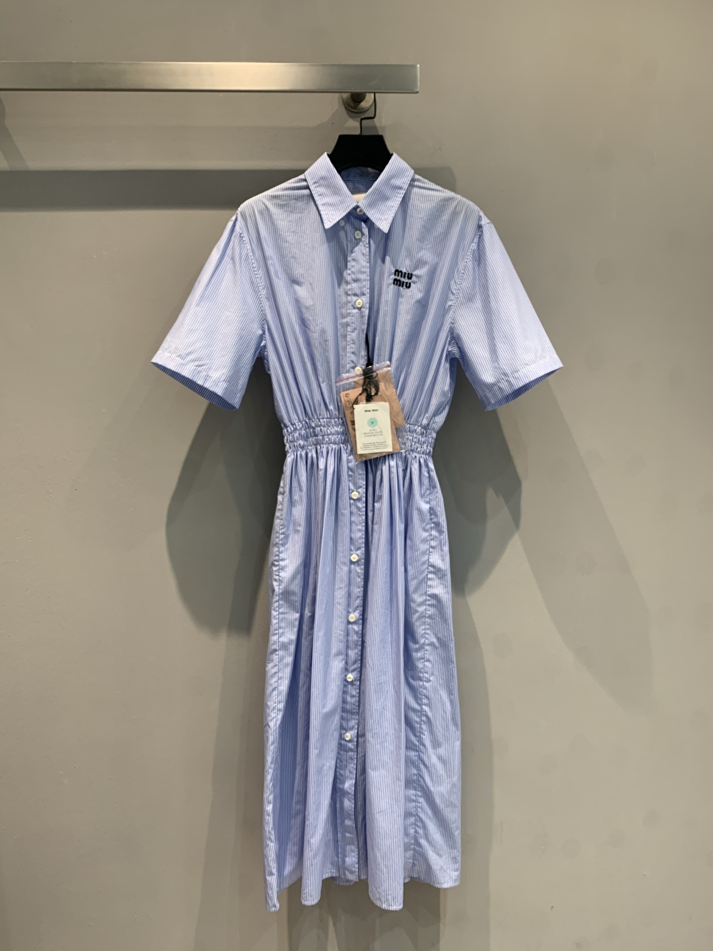 NO:417800,New models are shipped. Original development. Miumi*2025 spring and summer new small fresh embroidered logo-breasted waist shirt dress. It uses 100% pure cotton fabric. It is skin-friendly and breathable, with high-quality texture. The light blue strip comes with a fresh filter~ neat lapel + waist-closing design, which makes it look slim and hides flesh. The buttons are fully opened. It is also superb when pairing as a cardigan. Daily commuting and weekend trips, one-click to switch the relaxed atmosphere. Easily wear it to create an oxygen feeling, and whoever wears it looks good!  SML, miumiu, skirts, alexander wang19860909新款出货啦 原版开发 Miumi*2025春夏新款小清新刺绣logo排扣收腰衬衣裙.采用百分百纯棉面料.亲肤透气,质感高级.浅蓝条自带清新滤镜~利落翻领+收腰设计,显瘦又藏肉,纽扣全开,当开衫搭也超绝,日常通勤、周末出游,一键切换松弛氛围.轻松穿出氧气感,谁穿谁好看！码数SML,,miumiu,skirts,alexander wang,Women's clothing
