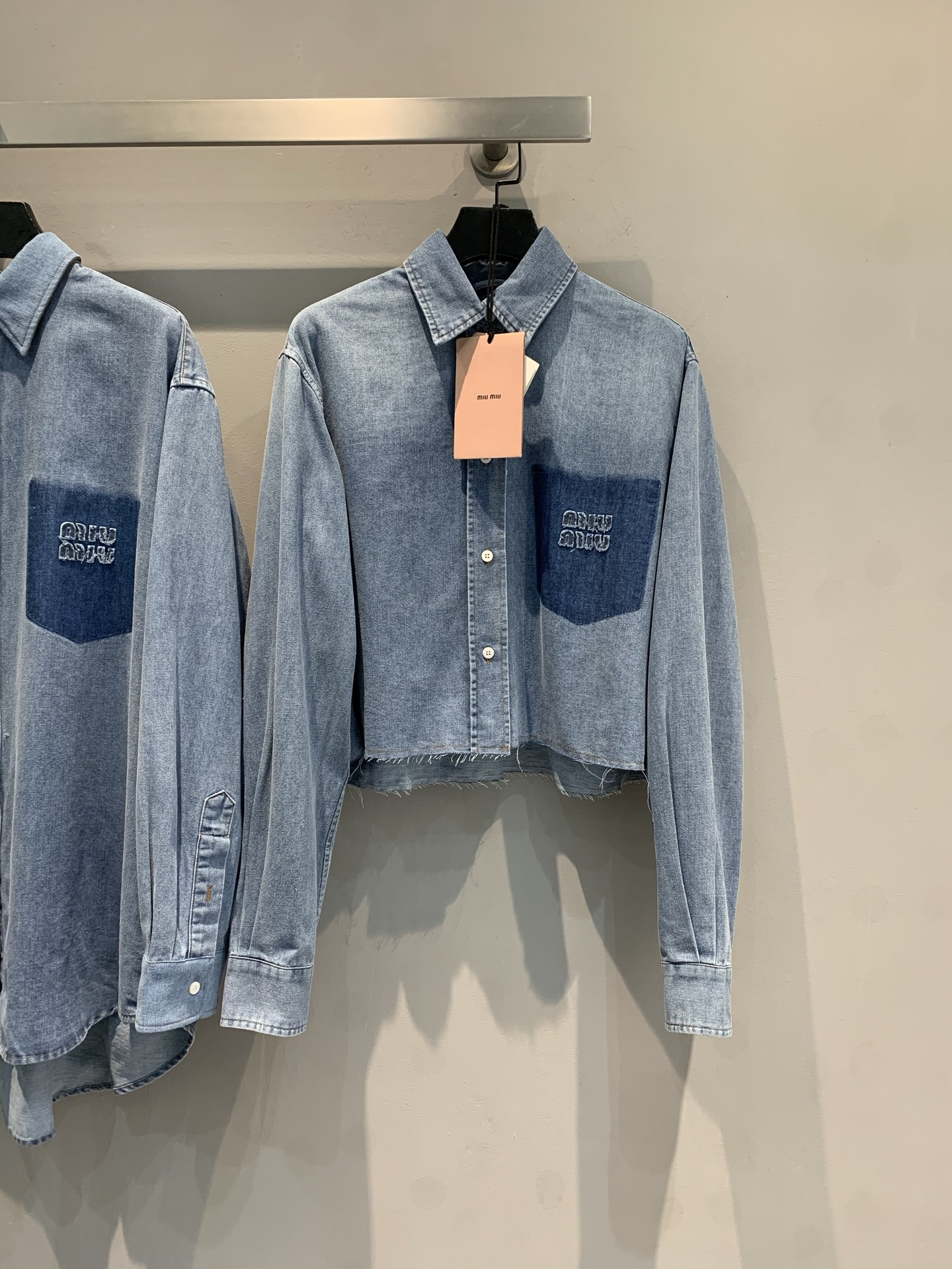 NO:336006,New model is shipped. Original development. Miumi*2025 early spring new retro letter logo denim shirt. It uses imported denim jean fabric, delicate and soft, and has a high-quality texture. The unique breasted hem adds an unruly attitude. The unique letter embroidery in the pocket of the chest injects details into the overall shape, exquisite and eye-catching. The short style is suitable for high-waist bottoms, which easily creates a perfect proportion. Whether it is a casual style with jeans to create the same color or a mix and match with a skirt, it can interpret a unique fashion attitude. SML, miumiu, skirts, jeans, shirts, alexander wang19860909新款出货啦 原版开发 Miumi*2025早春新款复古字母logo丹宁牛仔衬衫.采用进口丹宁牛仔面料,细腻柔软,质感上乘.个性的毛边下摆,增添不羁态度,胸前口袋处别致的字母刺绣,为整体造型注入细节亮点,精致又吸睛.短款版型适配高腰下装,轻松打造完美比例,无论是搭配牛仔裤打造同色系休闲风,还是与裙装混搭,都能诠释独树一帜的时尚态度.码数SML,,miumiu,skirts,jeans,shirts,alexander wang,Women's clothing