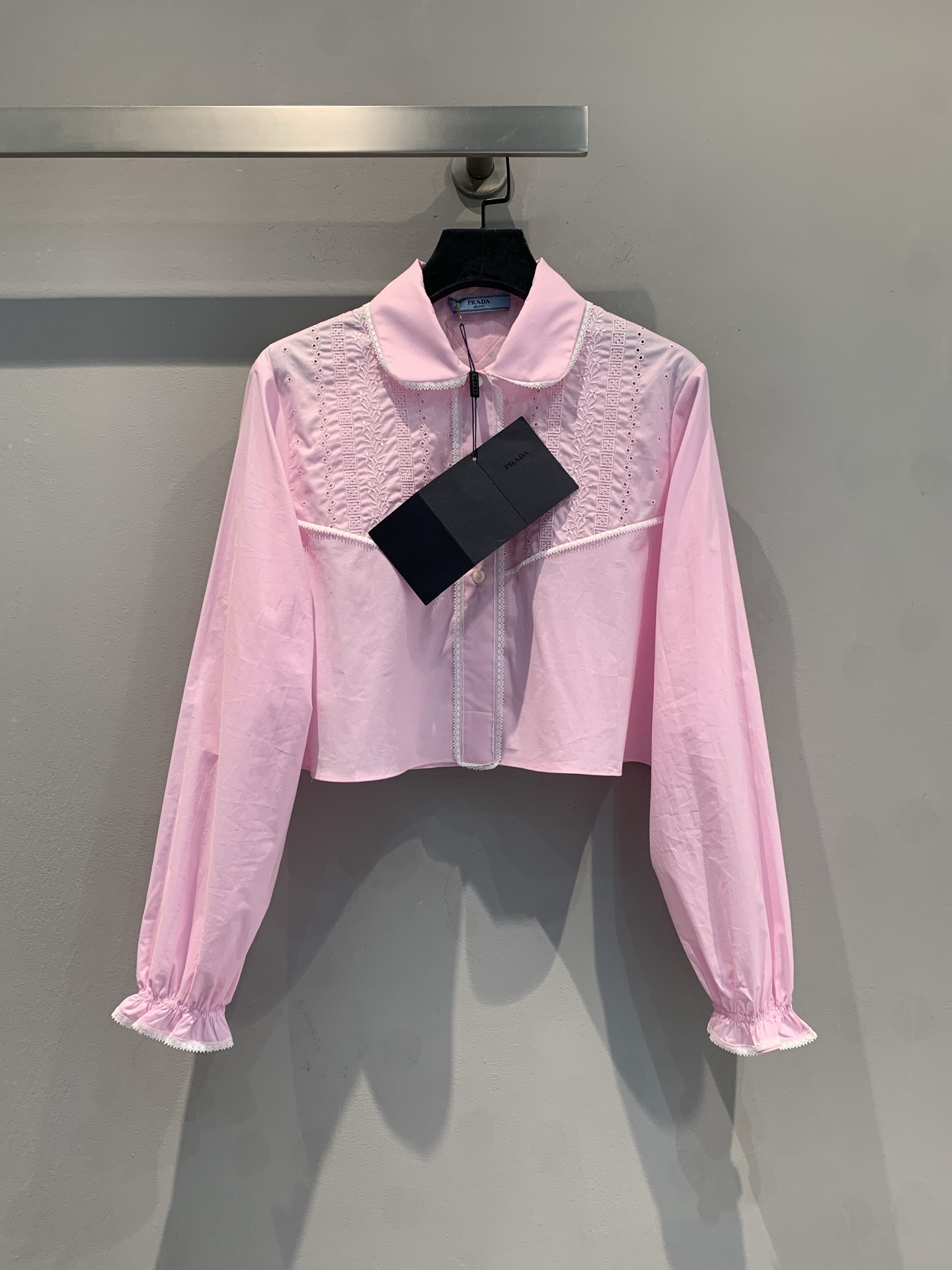 NO:333195,New model is shipped, original development Prad*2025 spring and summer new heavy-industry embroidered doll collar lace short shirt. The doll collar design outlines the soft lines of the neck. The exquisite white trim at the neckline and cuffs are like light morning dew, adding agility to the whole. The delicate embroidery patterns on the shoulders and chest are ingenious brushstrokes, engraved with luxury in simplicity. The puff sleeves are retro and fashionable, hiding the girl's dream. The short cut reveals the waistline just right, easily creating a graceful figure. Number of 36 38 40,,prada,shirts,alexander wang19860909新款出货啦 原版开发 Prad*2025春夏新款重工刺绣娃娃领花边短款衬衫.娃娃领设计,勾勒出颈部的柔美线条 .领口与袖口处精致的白色边饰,似轻盈的晨露,为整体增添灵动韵致.肩部与胸前细腻的刺绣花纹,是匠心独运的笔触,于简约中镌刻奢华.泡泡袖造型复古又时髦,藏着少女的绮梦.短款剪裁,恰到好处地露出腰线,轻松打造出曼妙身姿.码数36 38 40,,prada,shirts,alexander wang,Women's clothing