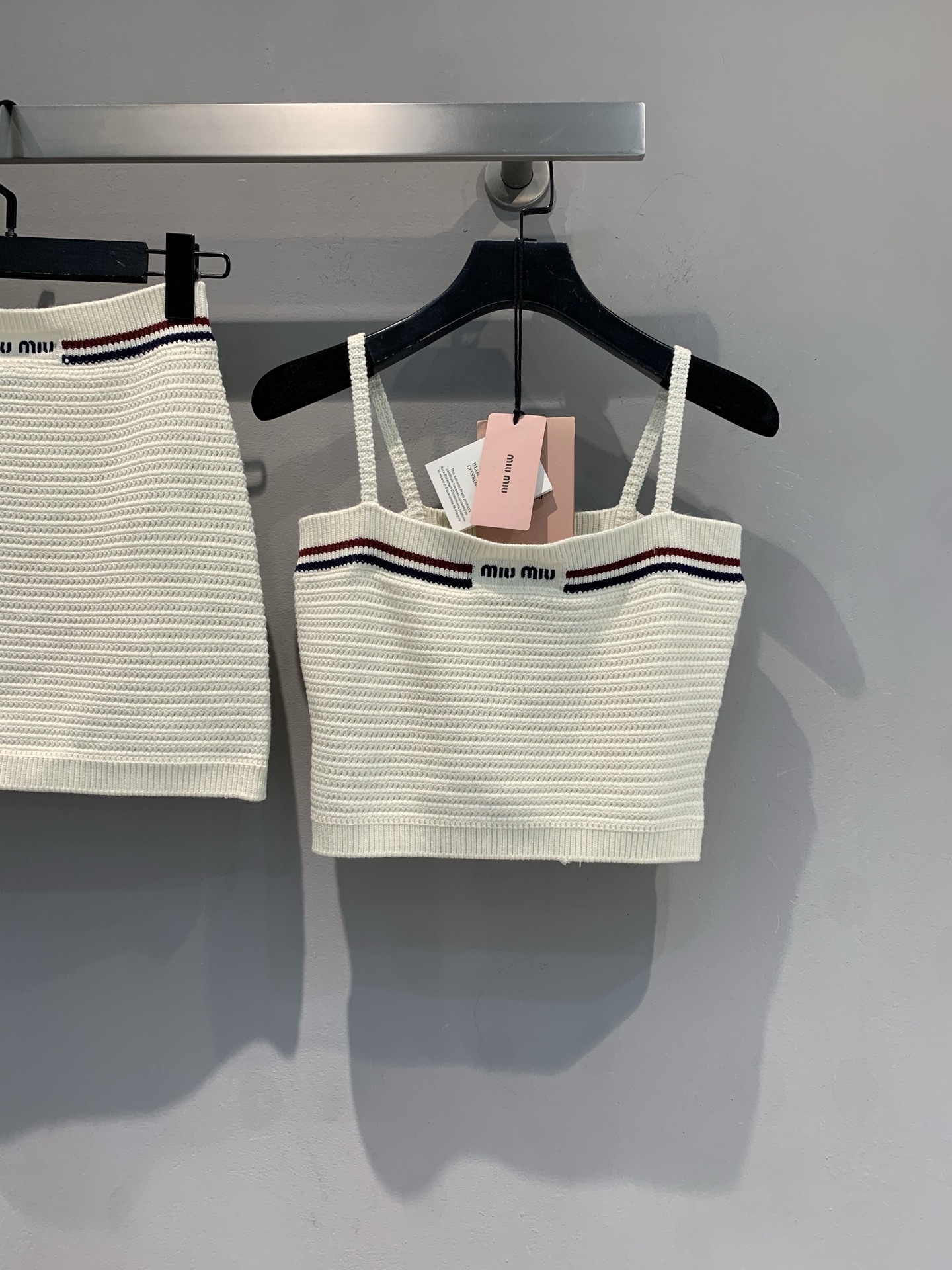 NO:420945,The new model is shipped. Original development. Miumi*2025 spring and summer new letter logo pit knitted suspenders. It uses cotton-elastic blended fabric, with delicate texture, skin-friendly and breathable. Imported machine knitting technology. Exquisite and fine shoulder straps, cleverly modify the shoulder and neck lines, revealing elegant temperament; the red, black and blue contrasting stripes and brand logo at the neckline inject playful vitality into the whole. Whether it is a single outfit with short skirts and shorts, showing a hot summer style, or a small suit to create a balance between the mother, you can easily come out of the circle and let you exude unique charm at all times. SML, miumiu, skirts, shorts, business suit, alexander wang19860909新款出货啦 原版开发 Miumi*2025春夏新款字母logo坑条针织吊带.采用棉纶混纺面料,质感细腻,亲肤透气.进口机针织工艺.精致细肩带,巧妙修饰肩颈线条,流露优雅气质；领口处红黑蓝撞色条纹与品牌标识,为整体注入俏皮活力.无论是单穿搭配短裙短裤,展现热辣夏日风情,还是外搭小西装打造娘man平衡,都能轻松出圈,让你时刻散发独特魅力.码数SML,,miumiu,skirts,shorts,business suit,alexander wang,Women's clothing