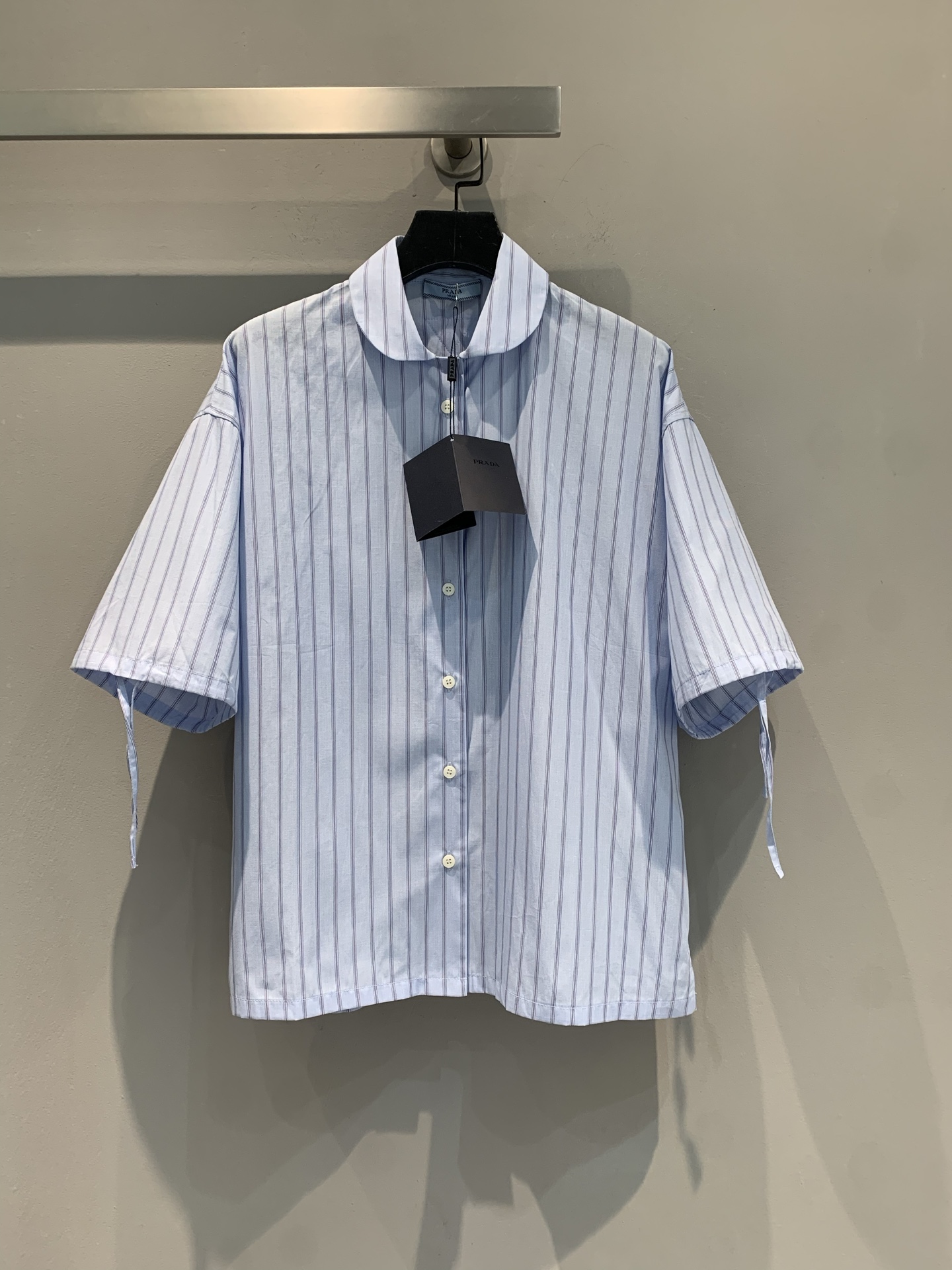 NO:429777,New model is shipped, original development Prad*2025 spring and summer new retro lace-up doll collar vertical striped short-sleeved shirt. It uses 100% pure cotton fabric, which is skin-friendly and comfortable and has good breathability. The striped short-sleeved shirt with a slack feel is so amazing. Light blue stripes + small lapels, fresh and age-reducing cuff streamers design, details hide the trick~ Loose silhouette, lazy and fashionable, and it is amazing to wear and layer it alone!  Daily commuting, weekend shopping, one piece of slack feeling, whoever wears is the 'oxygen beauty' this girl SML, prada,shirts,T-shirt,alexander wang19860909新款出货啦 原版开发 Prad*2025春夏新款复古系带娃娃领竖条纹短袖衬衫.采用百分百纯棉面料,亲肤舒适,透气性佳.自带松弛感的条纹短袖衬衫太绝啦 浅蓝条纹+小翻领,清新又减龄袖口飘带设计,细节藏着小心机～ 宽松廓形,慵懒又时髦,单穿叠穿都很绝！日常通勤、周末逛街,一件拿捏松弛感,谁穿谁是“氧气美女”本女 码数SML,,prada,shirts,T-shirt,alexander wang,Women's clothing