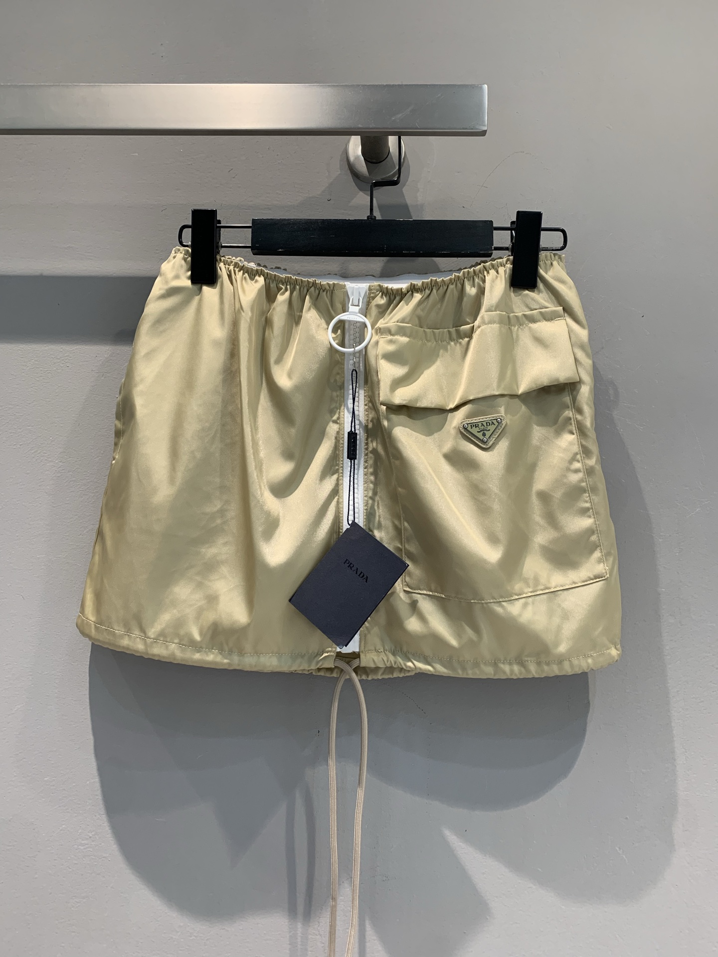 NO:433932,New model is shipped, original development Prad*2025 spring and summer new triangle-shaped large pocket zipper skirt. It uses imported recycled technology cotton-ammon fabric, high-quality texture and crisp style. Classic recycled cotton-ammon fabric, champagne gold has a glossy feeling, outdoor functional air pocket + metal buckle details, street cool and high-luxury genes are perfectly integrated~ elastic waist + drawstring design, to accommodate all kinds of figures, and it is 'easy and effortless fashionable'. It is full of spicy feeling with a short top. It can also play with a loose shirt and a lazy and relaxing feeling. The ambition of dressing is hidden in the details~ Want to break the dullness of the outfit?  This short skirt allows you to easily jump out of the 'passerby's a queue' and wear high-quality tastes in your daily life. SML, prada, skirts, shirts, alexander wang19860909新款出货啦 原版开发 Prad*2025春夏新款三角标大口袋拉链半裙.采用进口再生科技棉纶面料,质感高级,版型挺括.经典再生棉纶面料,香槟金自带光泽感,户外机能风口袋+金属扣细节,街头酷飒与高奢基因完美融合～松紧腰+抽绳设计,包容各种身形,随手一搭就是“毫不费力的时髦”,配短上衣辣感拉满 搭宽松衬衫又能玩慵懒松弛感,穿搭野心藏在细节里～想要打破穿搭沉闷感？这条短裙,让你轻松跳出“路人甲”队列,把高定品味穿在日常里.码数SML,,prada,skirts,shirts,alexander wang,Women's clothing