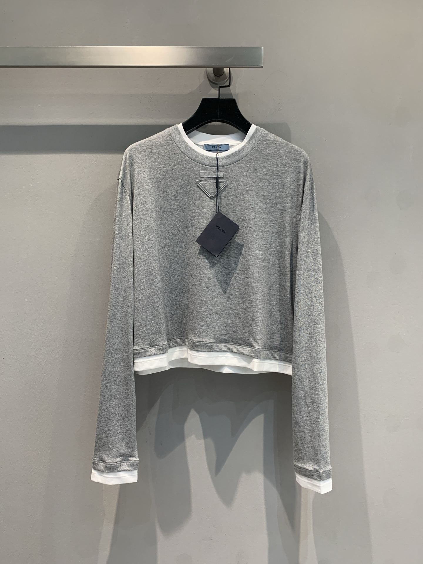 NO:435620,The new model is shipped. Original development vPrad*2025 early autumn new triangle mark contrasting color fake two-piece sweatshirt, light gray main tone is simple and high-end, white edge splicing outlines the sense of layering. The short-cut style lengthens the body, the classic triangle mark hides the brand genes, and daily pants and skirts have a relaxed and fashionable feeling, lazy and exquisite, easily grasp the relaxed and high-end feeling of early autumn outfits~ Don't miss out on fashionable things, and instantly become the best-wearing baby on the street. SML, prada, hoodie, sweatshirts, skirts, alexander wang19860909新款出货啦 原版开发vPrad*2025早秋新款三角标撞色假两件卫衣,浅灰主调简约高级,白边拼接勾勒利落层次感.短截版型拉长身形,经典三角标藏着品牌基因,日常搭裤装、裙装都自带松弛时髦感,慵懒又精致,轻松拿捏早秋穿搭的松弛高级感~ 时髦精别错过,穿上秒变街头最会穿的崽码数SML,,prada,hoodie,sweatshirts,skirts,alexander wang,Women's clothing