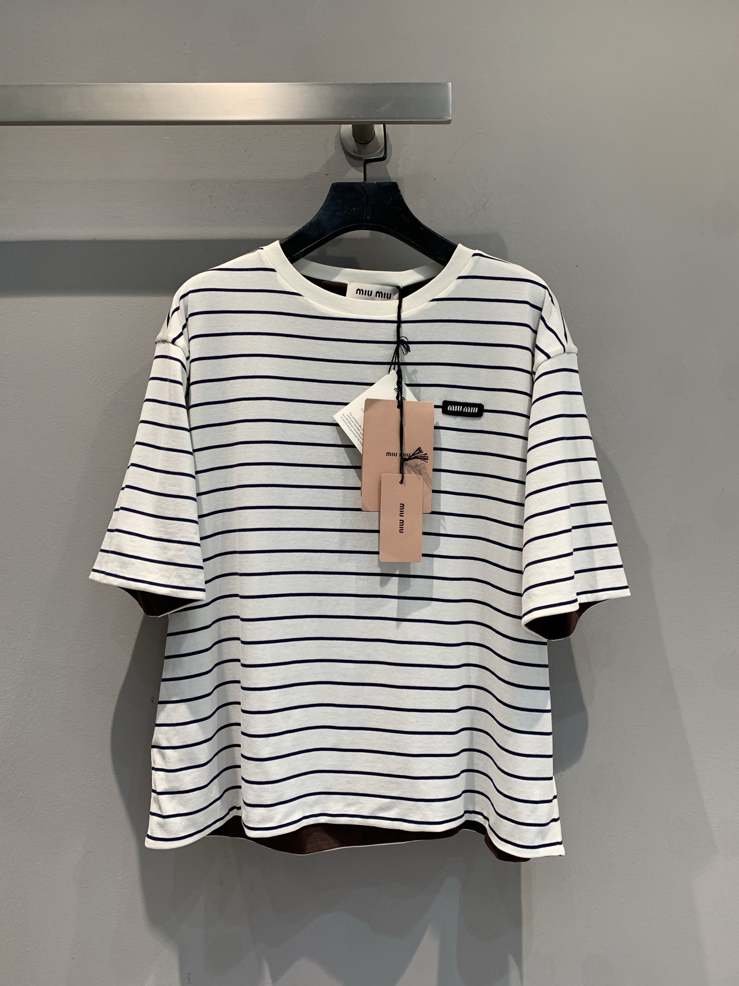 NO:448780,New model is shipped. Original real shot. Miumi*2025 summer new double-sided black striped short-sleeved T-shirt. Classic blue and white stripes are refreshing and healing. The color-blocking on the hem is hidden and tricky, loose silhouette, hidden flesh and casual, suitable for various body shapes, small labels on the chest are low-key to announce identity, and the relaxed feeling of daily going out and vacation can be grasped in one piece. SML, miumiu, T-shirt, tees, t-shirt, alexander wang19860909新款出货啦 原版实拍 Miumi*2025夏季新款双面穿黑标条纹短袖T恤.经典蓝白条纹清爽治愈,下摆拼色暗藏小心机,宽松廓形,藏肉又随性,适配各种身形,胸前小标低调宣告身份,日常出街、度假松弛感,一件就能拿捏.码数SML,,miumiu,T-shirt,tees，t-shirt,alexander wang,Women's clothing