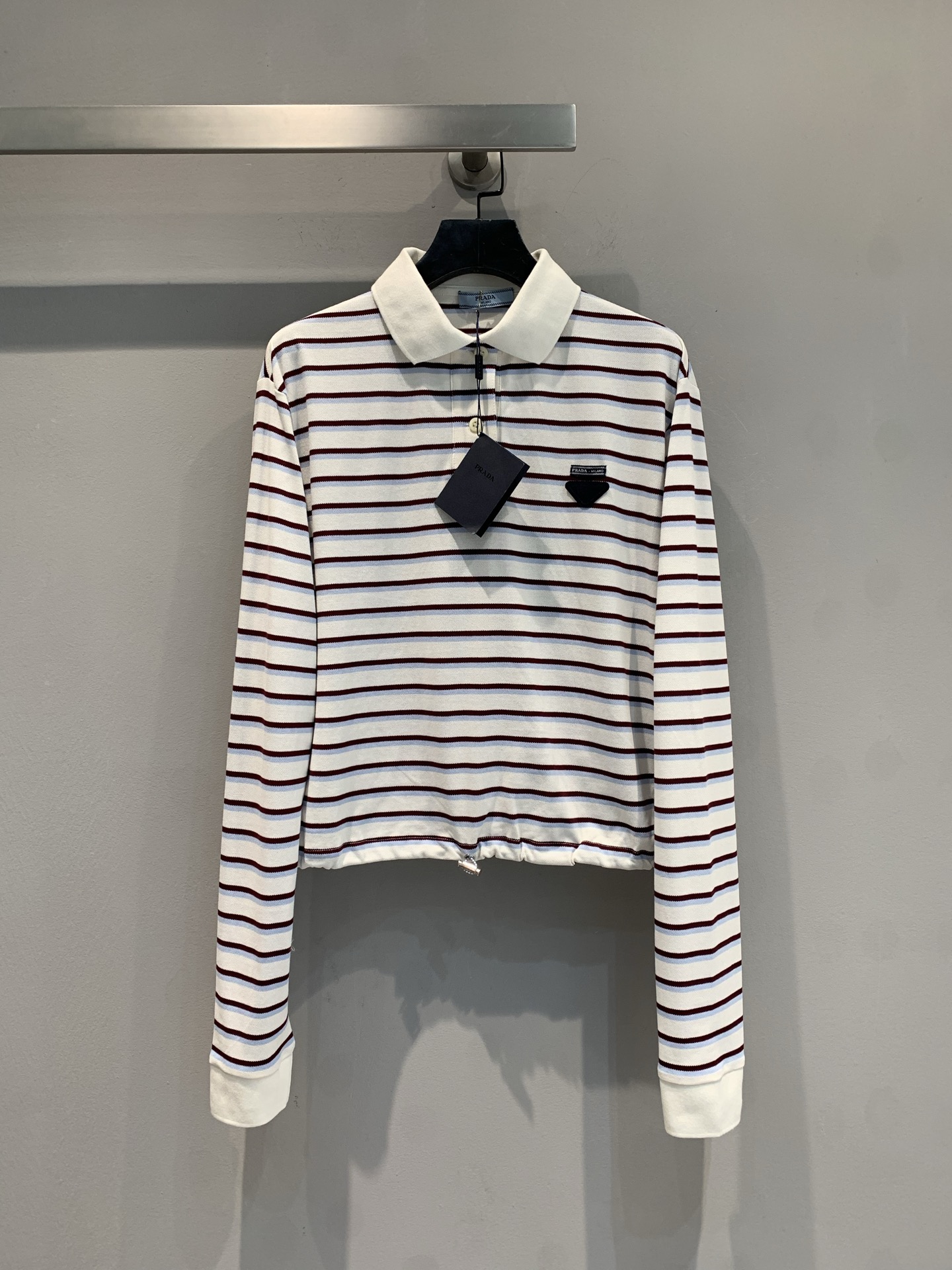 NO:446461,New style is shipped. Original development. Prad* early autumn new classic retro striped drawstring short top. Classic striped ecstasy short style + Polo collar design, retro and proportional. Who can see the small waist is exposed and the striped color is high-end, the small triangle punctuation on the chest is full of exquisiteness~ Long sleeves are suitable for many seasons, and they are excellent for high-waisted pants/short skirts. They are worn on daily streets and dates. They can easily grasp the noble and relaxed fabrics soft and skin-friendly, and are comfortable online. The 'atmosphere magic clothes' that is a must-have for fashionable wardrobe. When worn, they will directly transform into the street focus. SML, prada, skirts, alexander wang19860909新款出货啦 原版开发 Prad*早秋新款经典复古条纹抽绳短款上衣.经典条纹控狂喜短款+Polo领设计,复古又显比例,小腰一露谁看了不心动条纹配色高级,胸口小三角标点睛,精致感拉满～ 长袖适配多季节,搭高腰裤/短裙都绝,日常出街、约会穿,轻松拿捏贵气松弛感面料软糯亲肤,舒适度在线,时髦精衣柜必备的 “氛围神衣”,穿上直接化身街头焦点.码数SML,,prada,skirts,alexander wang,Women's clothing