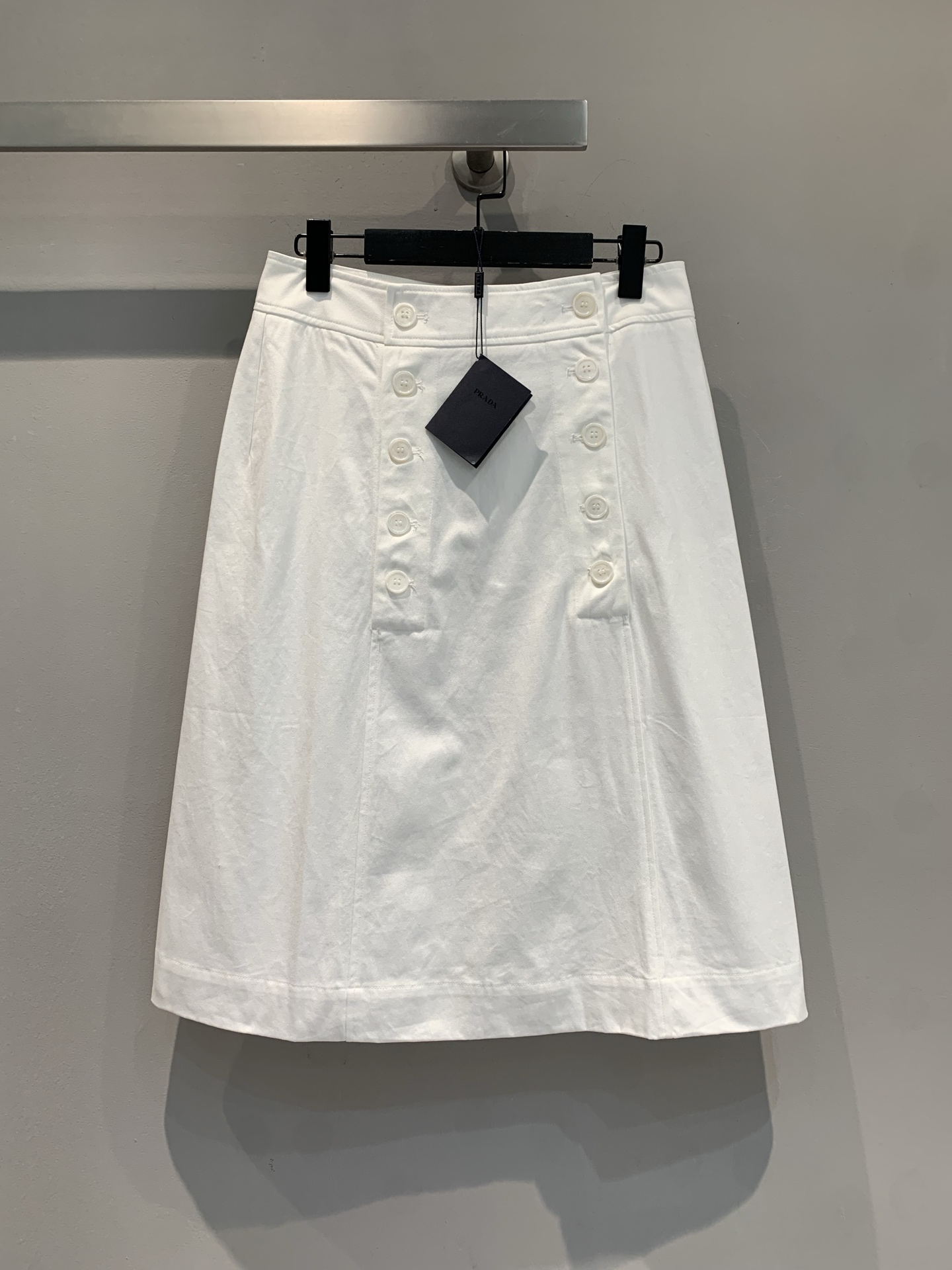 NO:445600,New model is shipped. Original development. Prad*2025 spring and summer new simple style double-breasted A-line skirt. The simple cut has a sense of high-end style. The double-breasted design hides tricks. The white is clean and elegant~ Daily wear shirts and T-shirts are excellent. Workplace commuting is capable, and it is gentle when going out for a date. Whoever wears it is the 'white moonlight on earth' and the wardrobe must have the king. SML, prada, skirts, shirts, tees, t-shirt, alexander wang19860909新款出货啦 原版开发 Prad*2025春夏新款简约风双排扣A字型半裙.简约剪裁自带高级感,双排扣设计藏着小心机,白色干净又显气质~ 日常搭衬衫、T恤都很绝,职场通勤干练,出街约会又温柔,谁穿谁是“人间白月光”,衣橱必备王炸单品.码数SML,,prada,skirts,shirts,tees，t-shirt,alexander wang,Women's clothing