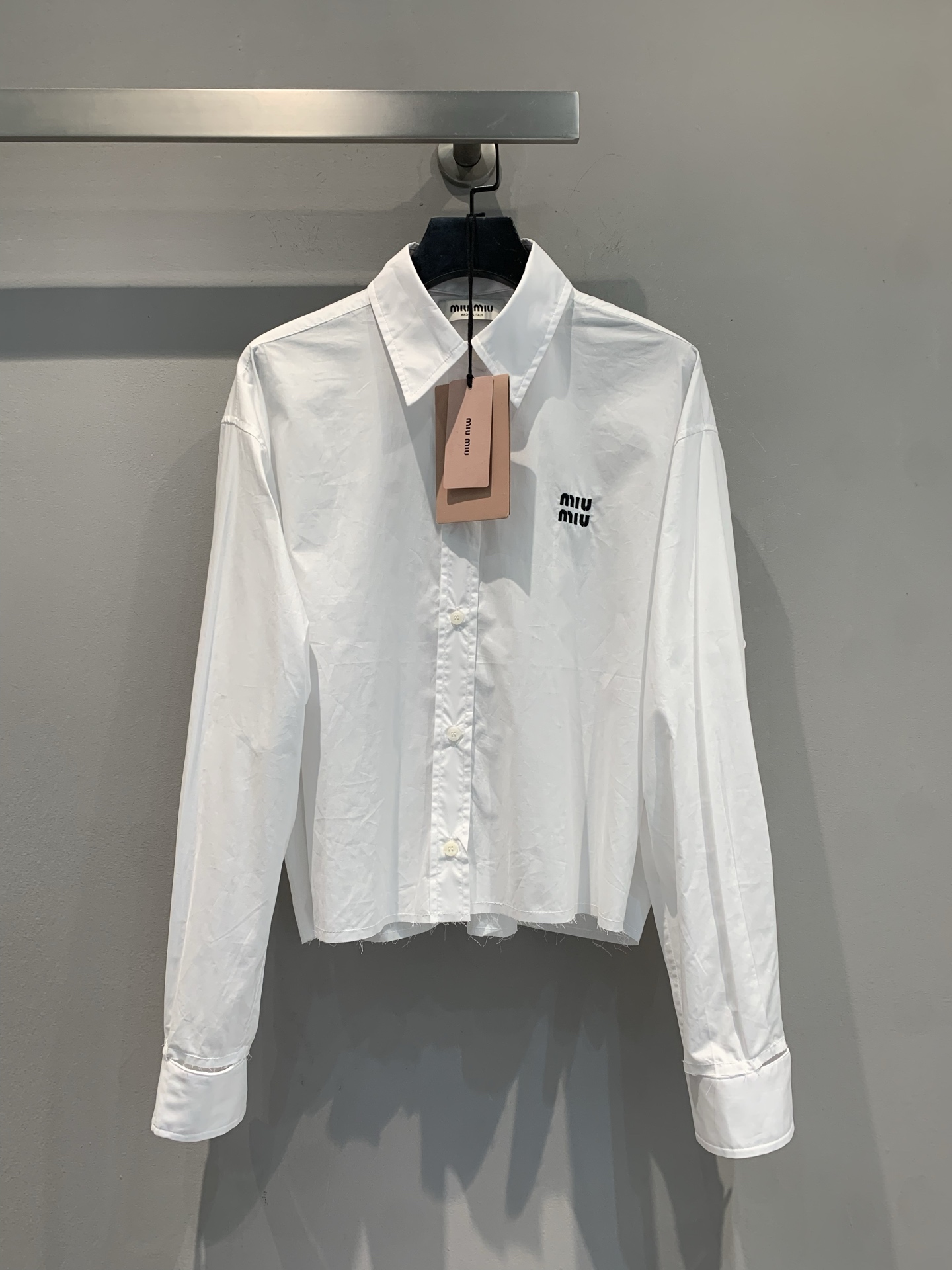 NO:451882,New models are shipped. Original development. Miumi*2025 early autumn new removable design letter logo short shirt. It uses 100% pure cotton fabric, which is skin-friendly and comfortable and has good breathability. The neckline and cuffs are detachable, and the exquisite feel is full. The short cut shows the proportion in one second. It is a must-have for hot girls!  The logo on the chest is low-key and eye-catching, with a rich daughter's slack feeling, you can wear it on daily streets, dates and commuting, whoever wears it is the peach code of the world, SML, miumiu,shirts,alexander wang19860909新款出货啦 原版开发 Miumi*2025早秋新款可拆卸设计字母logo短款衬衫.采用百分百纯棉面料,亲肤舒适,透气性佳.领口袖口均可拆卸,精致感拉满,短款剪裁一秒显比例,辣妹必备！胸前 Logo 低调又吸睛,自带富家千金松弛感,日常出街、约会通勤都能穿,谁穿谁是人间水蜜桃码数SML,,miumiu,shirts,alexander wang,Women's clothing