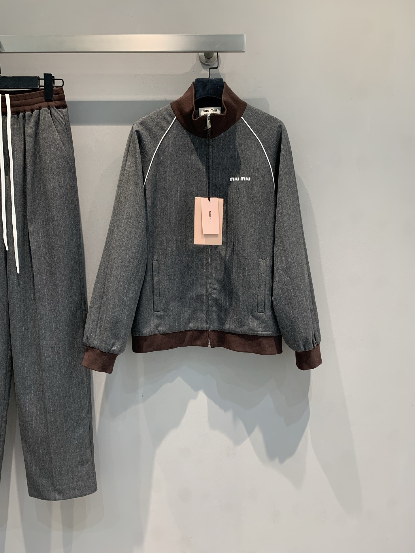 NO:465030,New style shipped out, original development Miumi 2025 early autumn new Academy style contrasting edge sports suit. It uses imported cotton wool fabric, with delicate texture and crisp style. The gray-brown color combination has a high-end feel, a small stand collar + zipper design, and it hides neatness in casualness. A set of tops and pants is complete, so you don’t have to worry about matching. You can wear it casually and be 'easy and effortless'. SML, miumiu, alexander wang19860909新款出货啦外 原版开发 Miumi2025早秋新款学院风撞色边运动套装.采用进口棉羊毛面料,质感细腻,版型挺括.灰棕配色自带高级感,小立领+拉链设计,休闲中藏着利落,上衣+裤子一套配齐,不用费心搭配,随手一穿就是“毫不费力的时髦”.码数SML,,miumiu,alexander wang,Women's clothing