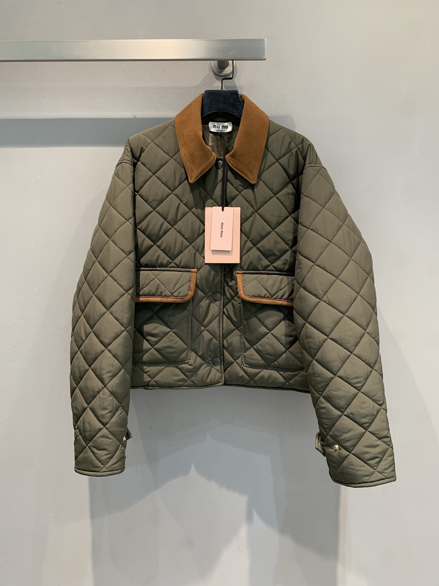 NO:507849,New style shipped M large-scale real shot Miumi* 2025 autumn and winter new fashionable retro contrast collar diamond quilted cotton jacket. Olive green quilted fabric comes with a retro filter, and the diamond plaid out three-dimensional layers between light and shadow, which is a modern interpretation of the classic silhouette; the caramel suede collar forms a contrasting contrast between the edges of the pocket, softening the tough feeling, and injecting a French retro elegant tone. The short cut raises the waistline and easily creates a 'three-seven-point' golden ratio. Whether it is matched with a pleated skirt, it goes to a sweet and cool girlish style, or with jeans, it can accurately hit the fashion beat. SML, miumiu, skirts, jeans, jackets & coats, chamois leather, gold, alexander wang19860909新款出货啦M大货实拍 Miumi*2025秋冬新款时髦复古撞色领菱格绗缝棉服夹克.橄榄绿绗缝面料自带复古滤镜,菱形格纹在光影间勾勒出立体层次,是经典廓形的摩登演绎；焦糖色麂皮领与口袋包边形成撞色反差,柔化硬朗感的同时,注入法式复古的优雅腔调.短款剪裁拉高腰线,轻松打造“三七分”黄金比例,无论是搭配百褶裙走甜酷少女风,还是配牛仔裤走复古休闲风,都能精准踩中时尚节拍.码数SML,,miumiu,skirts,jeans,jackets & coats,chamois leather,gold,alexander wang,Women's clothing