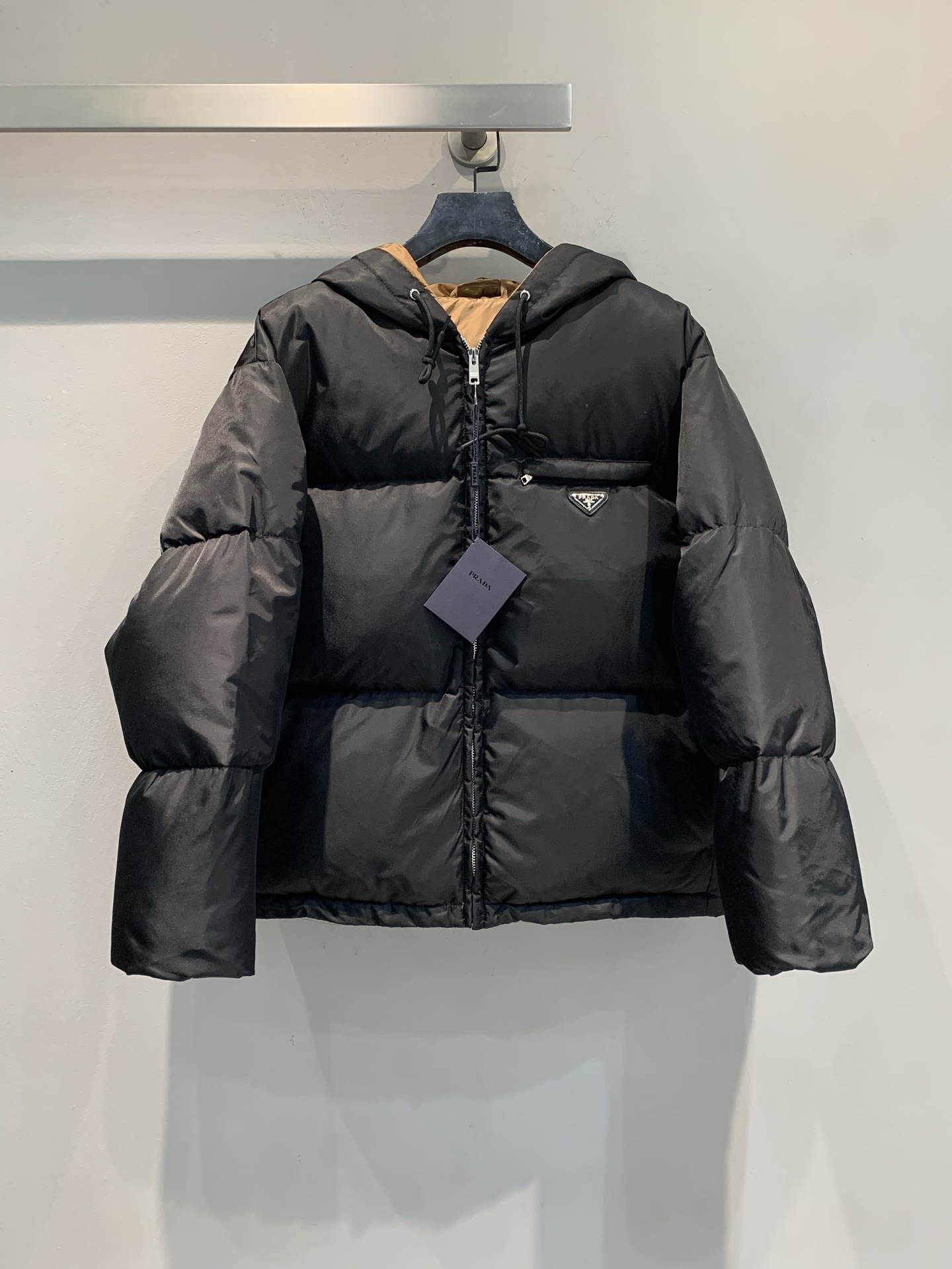 NO:544296,New style with dust bags shipped M large-scale real shot Prad* autumn and winter new fashionable and versatile triangle hooded down jacket. Matte black nylon fabric has a futuristic feeling, the national standard 90 white goose down fluffy volume firmly locks in the warmth; the hooded design is matched with drawstring details, hidden functional style ingenuity; the metal triangle logo on the chest is eye-catching, making the 'Prad* style high-end' clear on the streets of winter. The short silhouette is neat and not dragged, and the special cuff design injects personality into the shape, breaking the bloated stereotype of down jacket. SML, prada, down jacket, hats, alexander wang19860909配防尘袋新款出货啦M大货实拍 Prad*秋冬新款时髦百搭三角标连帽羽绒服.哑光黑尼龙面料自带未来感,国标90白鹅绒蓬松充绒量牢牢锁住暖意；连帽设计搭配抽绳细节,随性中暗藏机能风巧思；胸前金属三角徽标醒目张扬,让“Prad*式高级”在冬日街头一目了然.短款廓形利落不拖沓,特殊袖口设计为造型注入个性,打破羽绒服的臃肿刻板印象.码数SML,,prada,down jacket,hats,alexander wang,Women's clothing