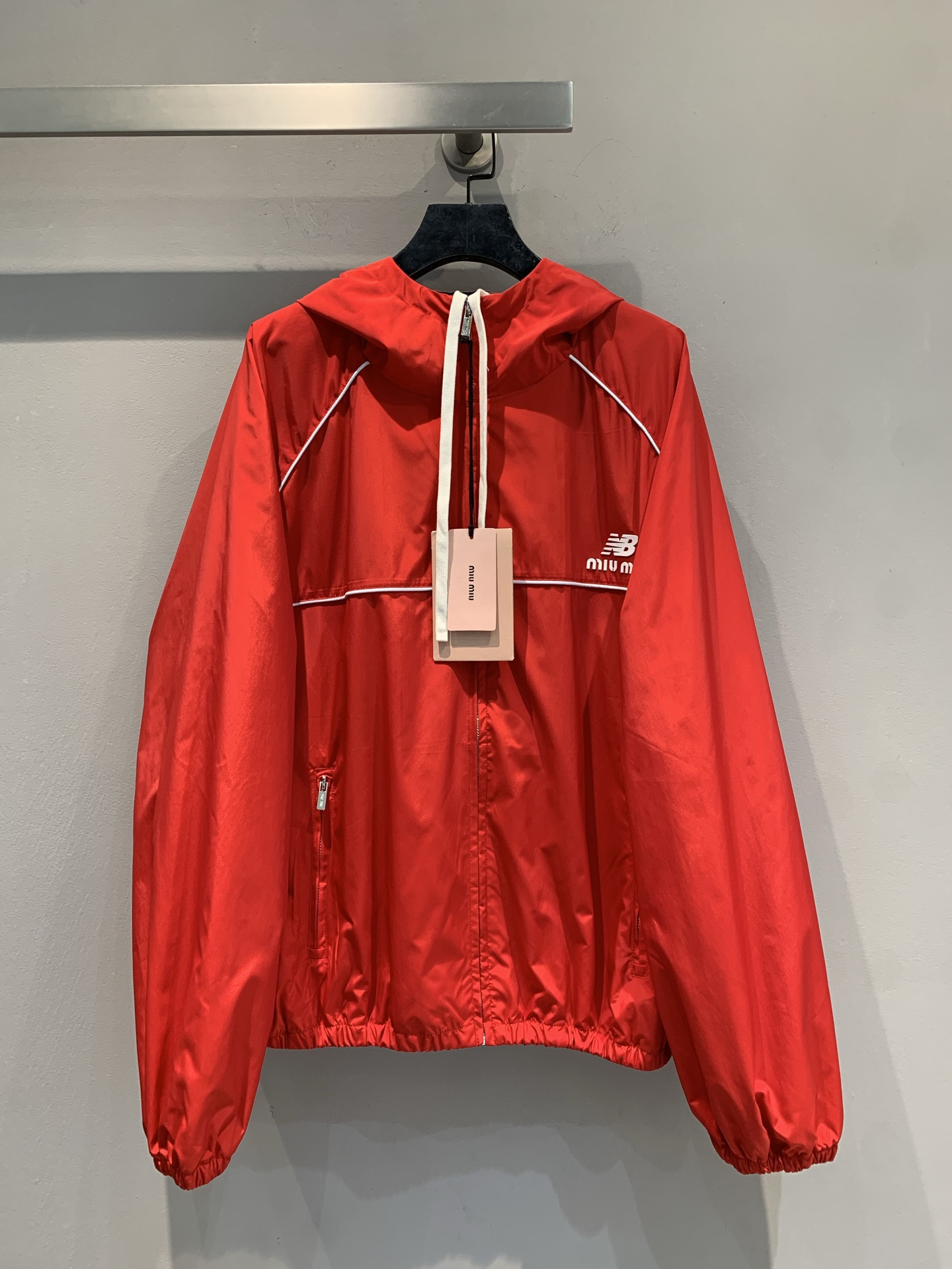 NO:544300,New model shipped by La M large-scale real shot Miumi* autumn co-branded hooded jacket. It uses imported recycled technology fabrics, which are light and comfortable, and have good breathability. The main tune of Dahong has a high-end feel, and the splicing white lines are neat and design; the hooded version + zipper design combines functionality and cool style. The double brand logo on the chest creates a different style spark, which is a 'styling weapon' for fashionable players. SML, miumiu, hats, alexander wang19860909新款出货啦M大货实拍 Miumi*秋季联名款系带连帽冲锋衣.采用进口再生科技面料,轻盈舒适,透气性佳.大红主调自带高级感,拼接白色线条利落又具设计感；连帽版型+拉链设计,兼具功能性与潮酷范儿,胸前双品牌标识碰撞出别样风格火花,是时尚玩家的“造型利器”.码数SML,,miumiu,hats,alexander wang,Women's clothing