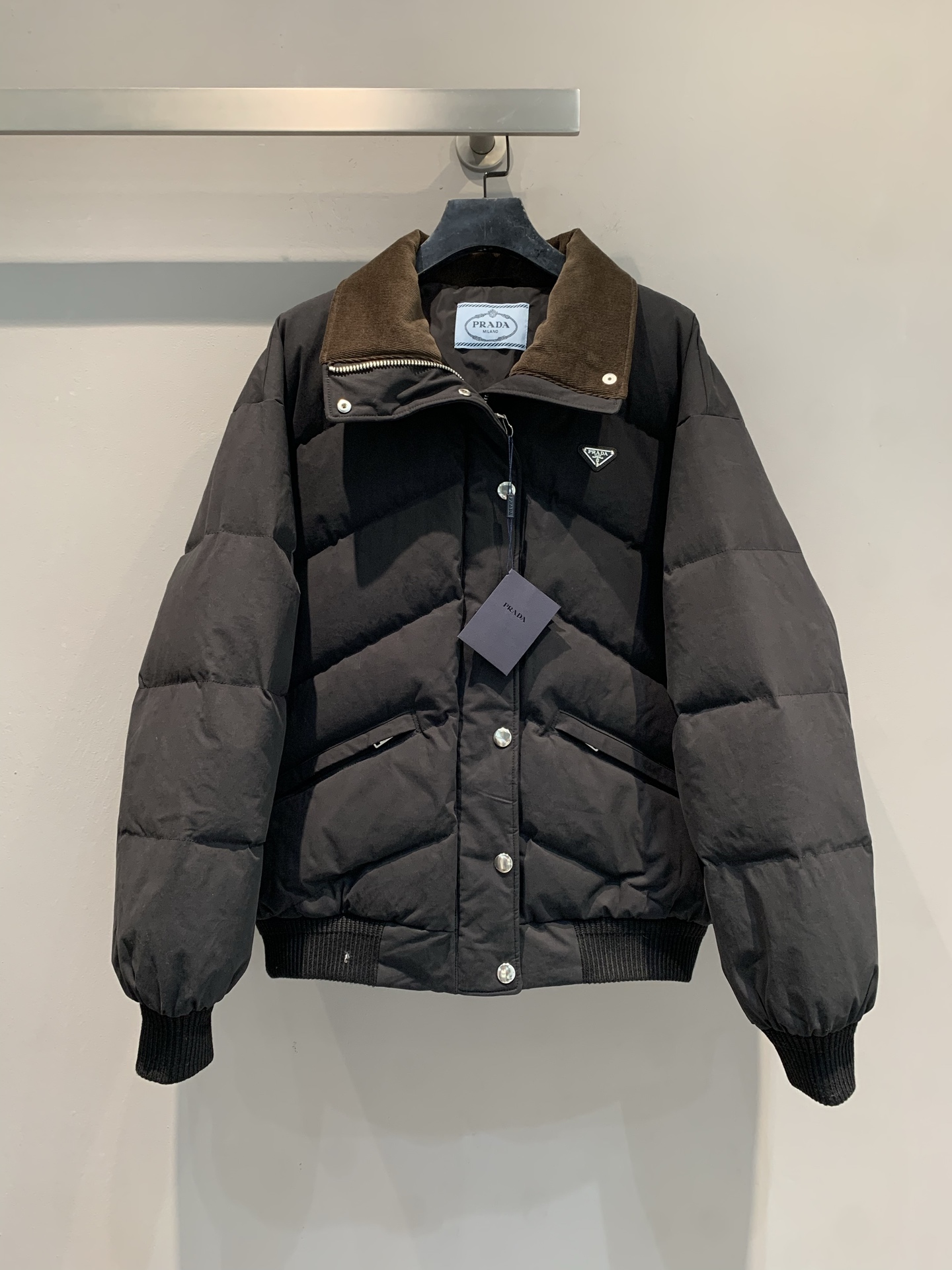 NO:546306,New style with dust bags shipped, big product real shot Prad*2025 autumn and winter new corduroy contrast collar triangle lapel down jacket. National standard 90 white goose down filling, light and warm. Corduroy spliced ​​lapel, retro and elegant, the iconic triangle logo is eye-catching, engraving the brand gene into the style core, and the three-dimensional quilting process locks the fluffy down, which not only gives the warmth and security needed in winter, but also uses the neat silhouette to refuse bloated, easily creating a 'lightweight' luxurious shape. SML, prada, down jacket, alexander wang19860909配防尘袋新款出货啦大货实拍 Prad*2025秋冬新款灯芯绒撞色领三角标翻领羽绒服.国标90白鹅绒填充,轻盈保暖.灯芯绒拼接翻领,复古又优雅,标志性三角徽标醒目点缀,将品牌基因刻入风格内核,立体绗缝工艺锁住蓬松羽绒,既给足冬日所需的温暖安全感,又凭借利落廓形拒绝臃肿,轻松打造“轻量感”奢华造型.码数SML,,prada,down jacket,alexander wang,Women's clothing