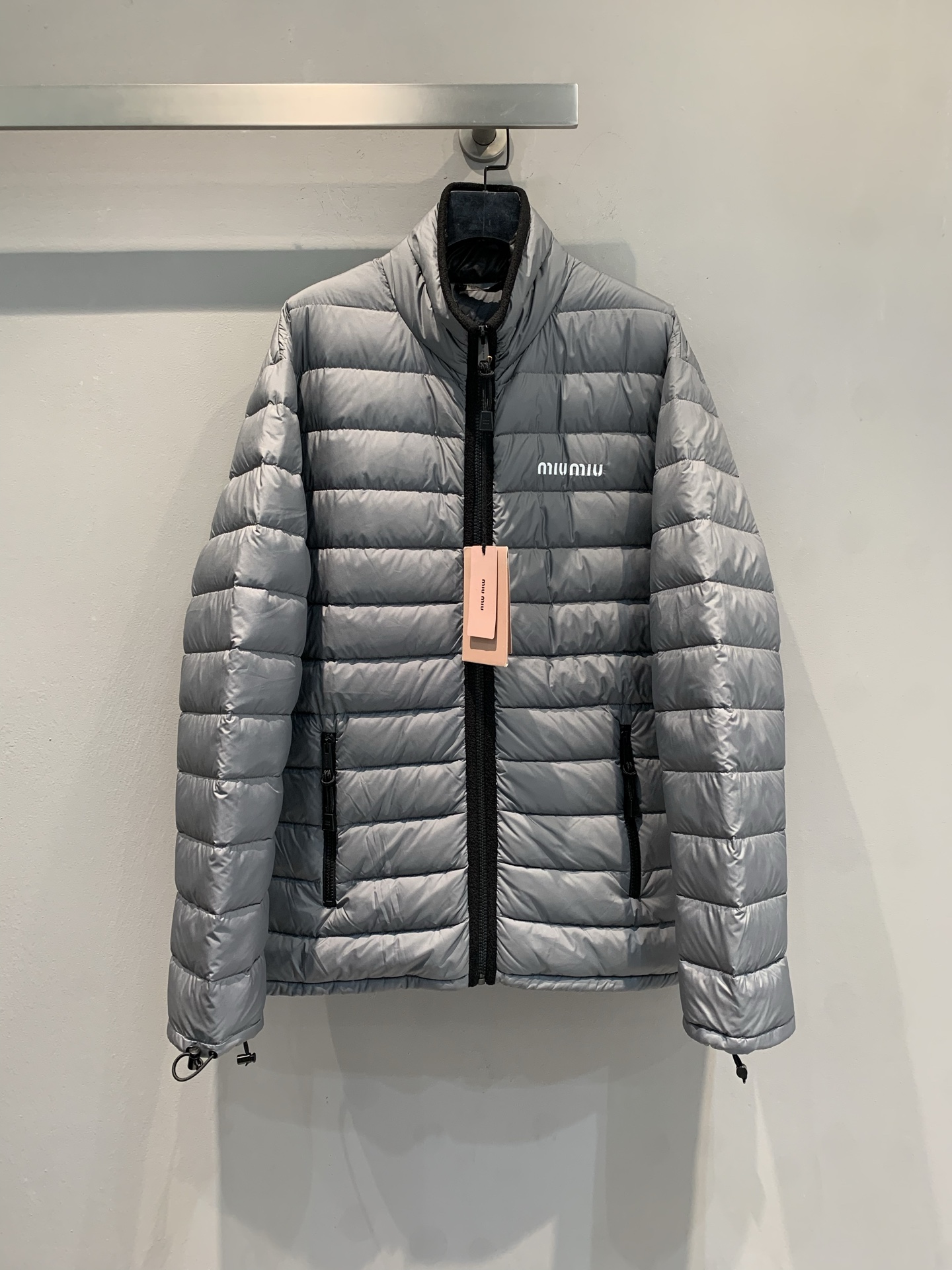 NO:562886,Equipped with dust bag, the new model has been shipped. M Real photos of the product. Miumi* 2025 new autumn and winter small stand-up collar down jacket, cross-cut pattern design + high-quality goose down filling, full of warmth! The outer layer is light and windproof, perfect for autumn and winter. The small stand-up collar + zipper is simple and practical, and the front brand logo enhances recognition. The cuffs and hem are adjustable to adapt to different wear needs. It can be easily used for daily commuting or light outdoor use, and it is both fashionable and functional. It is a must-have item in the winter wardrobe!  Size SML,,miumiu,down jacket,alexander wang19860909配防尘袋新款出货啦M大货实拍 Miumi*2025秋冬新款小立领羽绒服,横切纹设计+高品质鹅绒填充,保暖力满分!外层轻薄防风,秋冬穿超合适.小立领+拉链,简约又实用,正面品牌标识提升辨识度.袖口和下摆可调节,适应不同穿搭需求.日常通勤或轻户外都能轻松驾驭,兼具时尚与功能性,是冬季衣橱必备单品! 码数SML,,miumiu,down jacket,alexander wang,Women's clothing