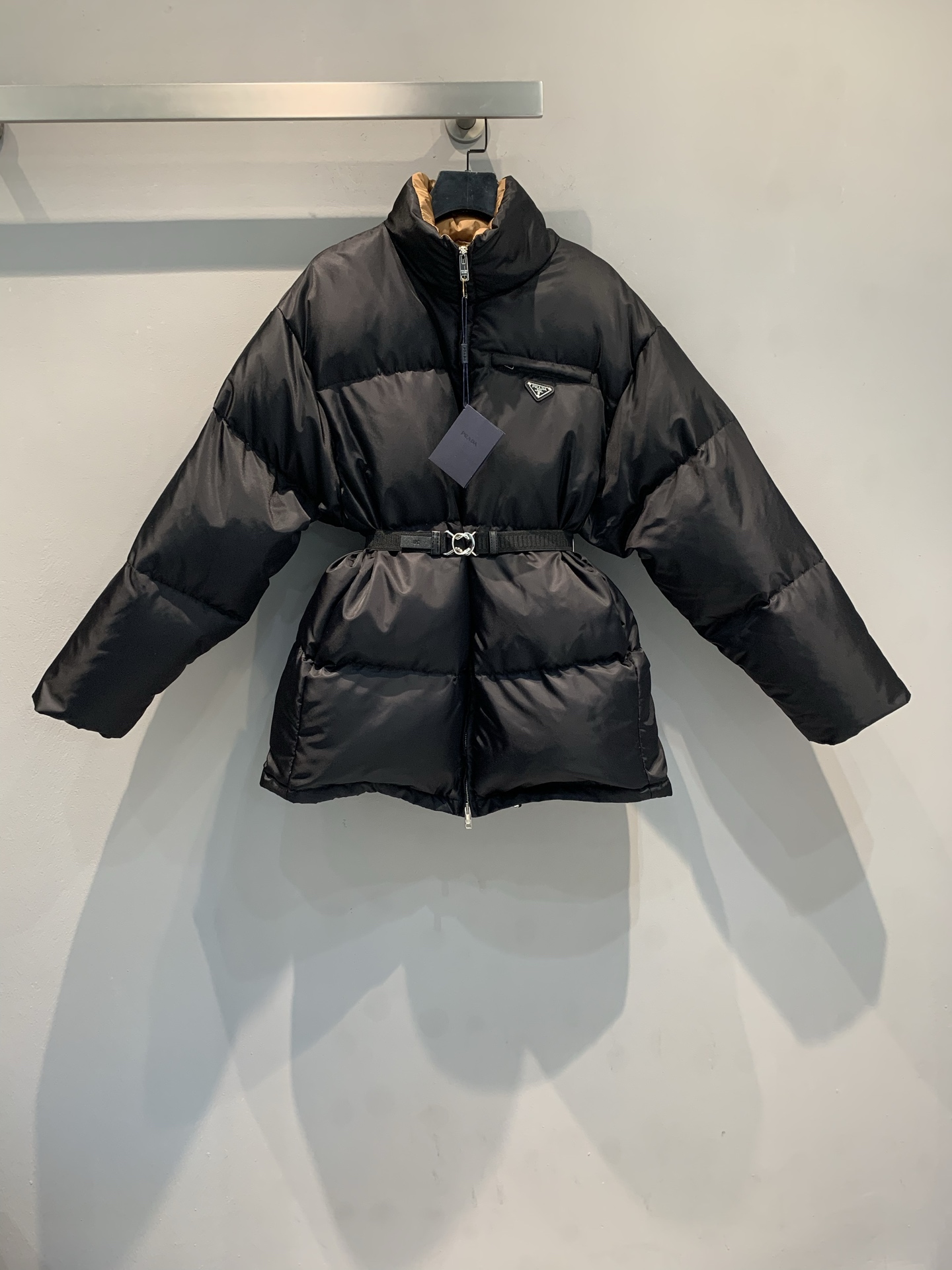 NO:560971,Comes with dust bag, new model shipped. Actual photos of the product. Prad* 2025 new autumn and winter fashionable and versatile stand-up collar triangle logo mid-length down jacket, filled with black glossy nylon and white duck down, perfect for warmth! The belt design can be worn at the waist or open, super versatile. The interior is haze blue color matching, full of details, and the lapel can also expose the inner, giving it a layered feel! The fabric is windproof and waterproof, suitable for commuting or outdoor, practical and fashionable, a must-have for autumn and winter wardrobes!  Size SML,,prada,down jacket,alexander wang19860909配防尘袋新款出货啦大货实拍 Prad*2025秋冬新款时髦百搭立领三角标中长款羽绒服,黑色亮面尼龙白鸭绒填充,保暖力满分!腰带设计可收腰or敞开穿,超百搭计.内里雾霾蓝拼色,细节感拉满,翻领还能露出内里,层次感up!面料防风防水,通勤or户外都OK,实用又时髦,秋冬衣橱必备! 码数SML,,prada,down jacket,alexander wang,Women's clothing