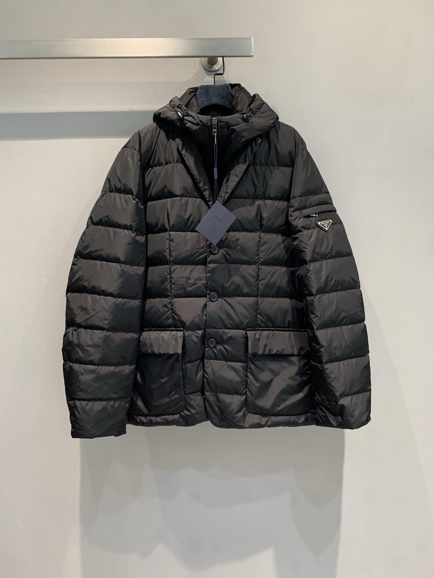 NO:605277,M Prad* 2025 new autumn and winter new triangle logo men's hooded down jacket with dust bag is shipped. It is filled with goose down and has perfect warmth! The outer layer is made of high-end regenerated nylon, which is windproof, waterproof and environmentally friendly. Oversized silhouette + hooded design, fashionable and practical, and the triangle logo on the left arm is very recognizable. Black is versatile and can be easily worn for business and leisure. It is a must-have item for the winter wardrobe! Size SML, prada, versace, down jacket, hats, alexander  wang19860909配防尘袋新款出货啦M Prad*2025秋冬新款三角标男士连帽羽绒服,采用鹅绒填充,保暖力满分!外层是高端再生尼龙,防风防水还环保..Oversized廓形+连帽设计,时尚又实用,左臂三角徽标超有辨识度计.黑色百搭,商务休闲都能轻松驾驭,是冬季衣橱必备单品! 码数SML,,prada,versace,down jacket,hats,alexander wang,Women's clothing