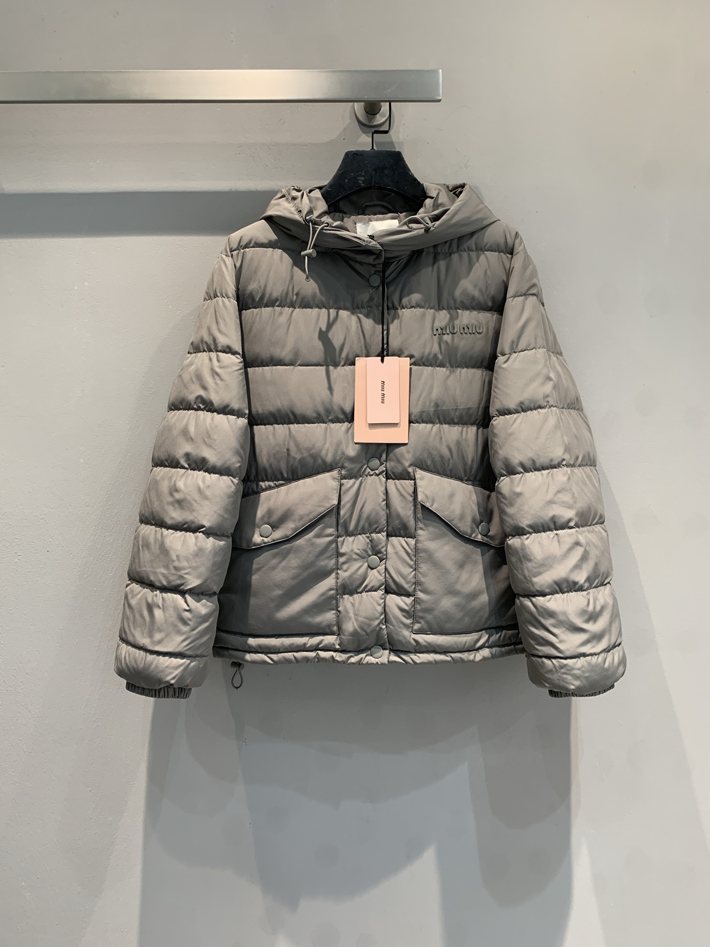 NO:606799,M Miumi* 2025 new autumn/winter charcoal gray hooded down jacket with dust bag is now available. It has a short hooded design, is filled with high-quality down, and has excellent warmth retention! The outer layer is windproof, which is very suitable for autumn and winter. There are brand logos and two flap pockets on the front, which are full of details. The cuffs and hem are elasticated, and the windproof effect is even better. It can be easily used for daily commuting or leisure, fashionable and practical, and it can be matched with any style!  Size SML,,miumiu,down jacket,hats,alexander wang19860909配防尘袋新款出货啦M Miumi*2025秋冬新款炭灰色连帽羽绒服,短款连帽设计,填充高品质羽绒,保暖力满分!外层防风,秋冬穿超合适.正面有品牌logo和两个翻盖口袋,细节感拉满计.袖口和下摆弹性收口,防风效果更赞.日常通勤或休闲都能轻松驾驭,时尚又实用,怎么搭都很有范儿! 码数SML,,miumiu,down jacket,hats,alexander wang,Women's clothing
