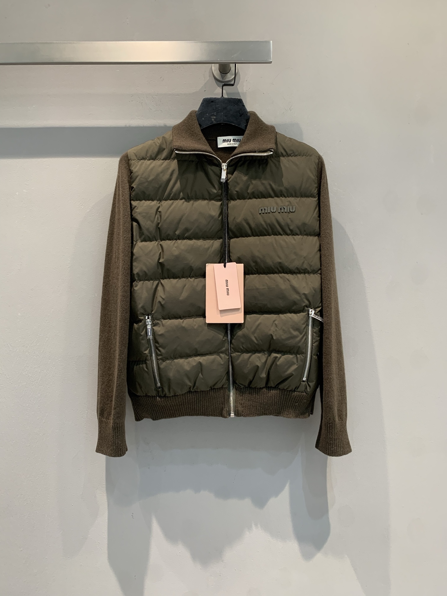 NO:606805,New model shipped with dust bag M  Miumi*2025 new fashionable retro cashmere sleeve knitted splicing down jacket for autumn and winter, filled with olive green down, with tear-proof outer fabric and vertical stripes of the same color, full of layering. The sleeves are brown knitted with rib design, comfortable and fashionable. The stand-up collar zipper style has the brand logo on the front, which is highly recognizable! It is super easy to layer in autumn and winter, warm and not bloated, and can easily create a high-end look. Size SML,, miumiu, down  jacket,alexander wang19860909配防尘袋新款出货啦M Miumi*2025秋冬新款时髦复古羊绒袖针织拼接羽绒服,橄榄绿羽绒填充,外层防撕裂面料,搭配同色竖条纹,层次感满满计.袖子是棕色针织,罗纹设计,舒适又时髦.立领拉链款,正面有品牌logo,辨识度超高!秋冬叠穿超方便,保暖又不臃肿,轻松打造高级感穿搭.码数SML,,miumiu,down jacket,alexander wang,Women's clothing