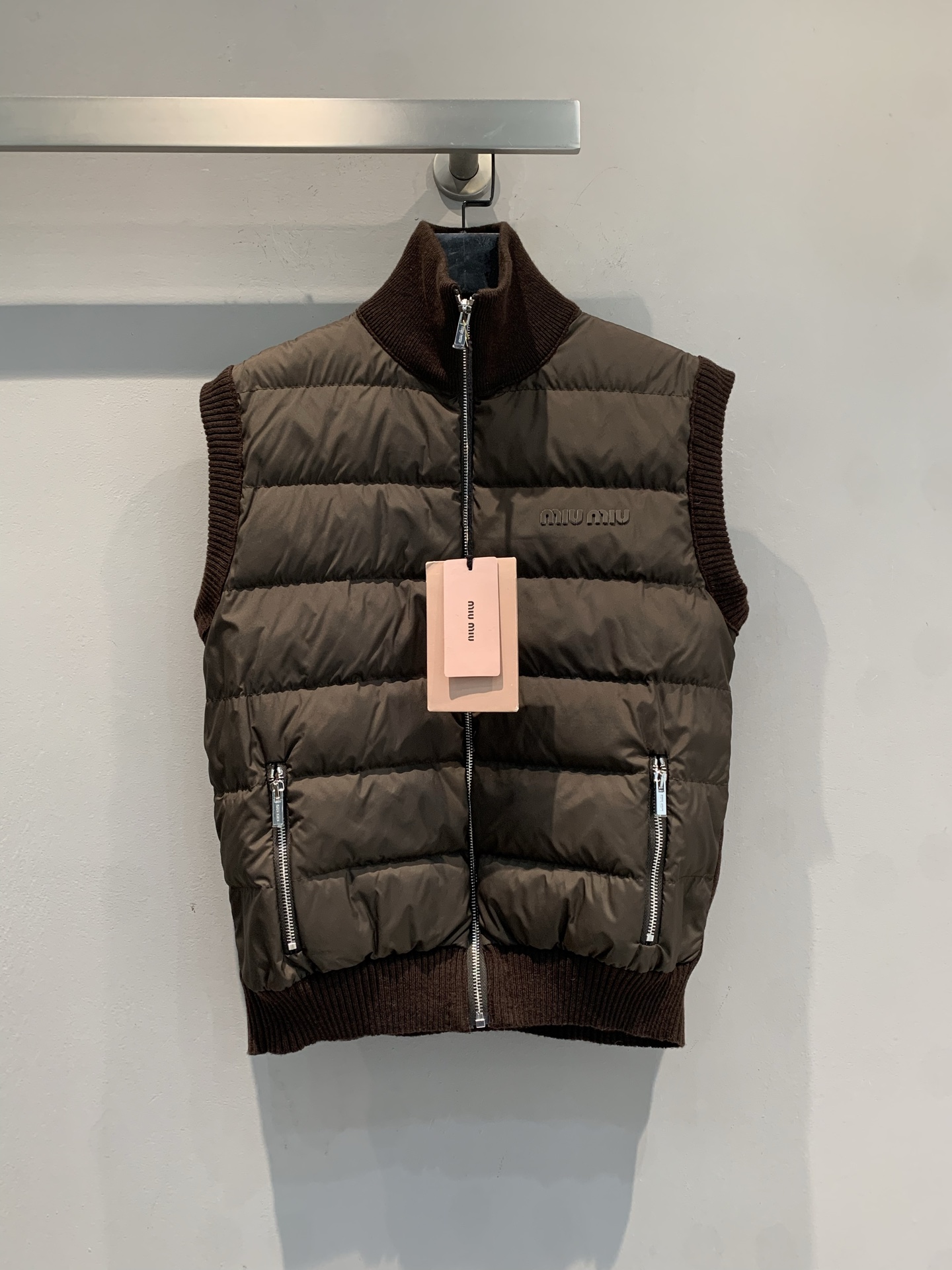 NO:624770,Equipped with a dust bag, the new model is shipped. MMiumi* 2025 new fashionable retro cashmere knitted stitching goose down vest for autumn and winter. The front is made of dark brown down, and the back and sleeves are made of soft cashmere knit. It is warm and textured. The high collar + rib cuff design is windproof and not bloated, the zipper is smooth, and the side pockets are super practical. It is OK whether worn with jeans, short skirts or as an inner layer, giving you a high-end look in autumn and winter!  Size SML,,miumiu,skirts,jeans,down jacket,alexander wang19860909配防尘袋新款出货啦MMiumi*2025秋冬新款时髦复古羊绒针织拼接鹅绒马甲,前片是深棕羽绒,后片和袖子是柔软羊绒针织,保暖又有质感计.高领+罗纹收口设计,防风不臃肿,拉链顺滑,侧袋超实用.无论搭牛仔裤、短裙还是做内搭都很OK,秋冬穿出高级感! 码数SML,,miumiu,skirts,jeans,down jacket,alexander wang,Women's clothing