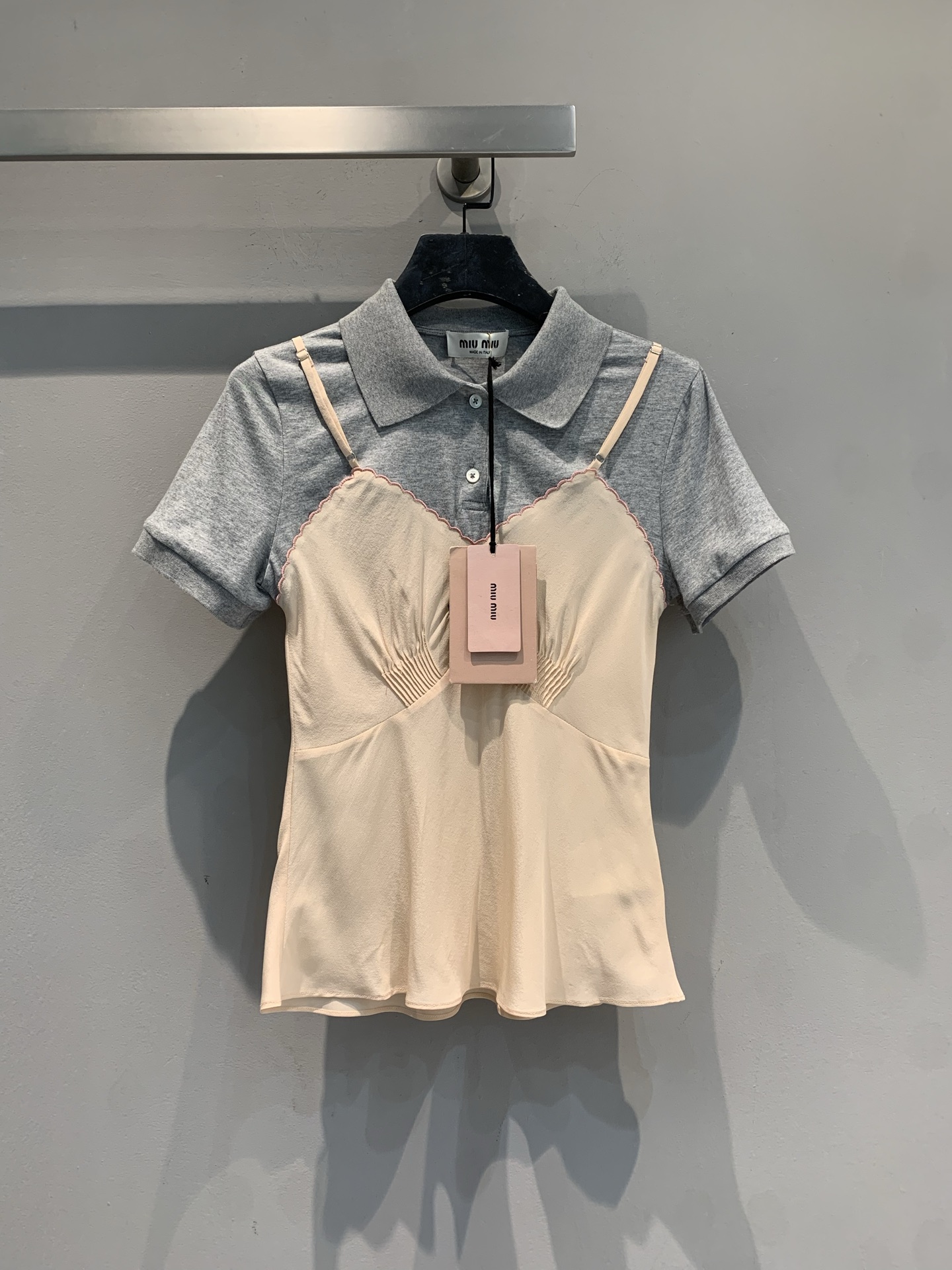 NO:683207,The new model has arrived. MMiumi*2026 early spring new trendy retro fake two-piece spliced short-sleeved, gray polo shirt + nude pink silk suspenders, casual and feminine at the same time. The silk fabric is soft and delicate, the shoulder straps are adjustable, and the details are perfect. The brand logo on the chest is highly recognizable. Paired with jeans or skirts, you can easily switch between sweet and cool or elegant style. It is suitable for daily outings and dates. A must-have for atmosphere!  Size SML,,miumiu,skirts,jeans,T-shirt,real silk,19860909新款出货啦MMiumi*2026早春新款时髦复古假两件拼接短袖,灰色 Polo衫+裸粉真丝吊带,休闲与柔美兼具.真丝面料柔软细腻,肩带可调节,细节满分.胸前品牌标识,辨识度高.搭配牛仔裤或半裙,轻松切换甜酷or优雅风,日常出街,约会都很适合,氛围感穿搭必备! 码数SML,,miumiu,skirts,jeans,T-shirt,real silk,,Women's clothing