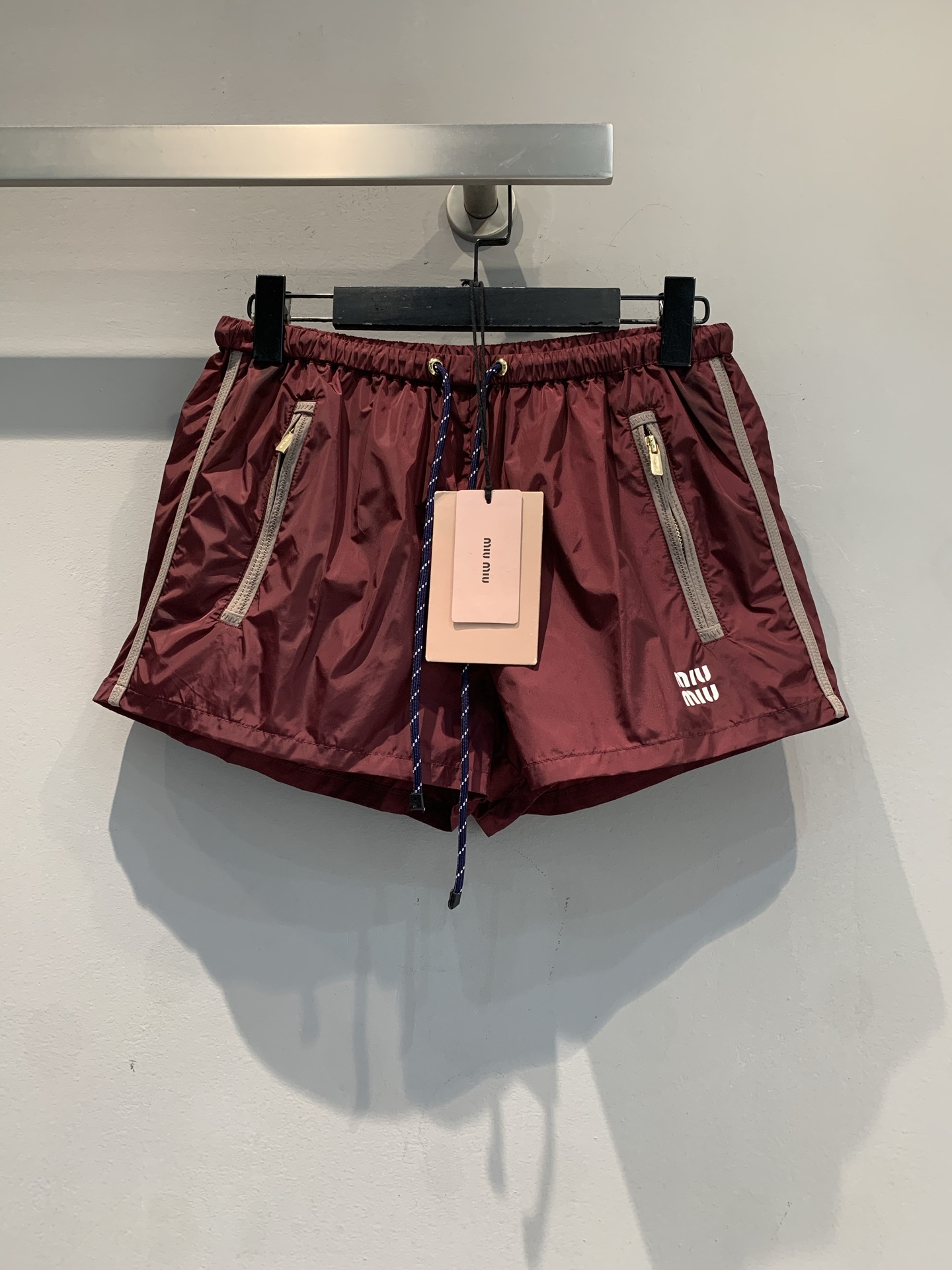 NO:709350,The new model is shipped. M original development Miumi*2026 early spring new fashionable retro burgundy sports shorts, light and quick-drying fabric, super breathable in summer!  The drawstring elastic waist + zipper pockets are practical and fashionable. The side stripes and brand embroidery are highly recognizable, making it easy to style sports and leisure. The loose fit accommodates a variety of body shapes and is OK for daily or sports use. Pair it with a top of the same color to easily get a high-end look!  Code numberSML,,miumiu,shorts,19860909新款出货啦M原版开发 Miumi*2026早春新款时髦复古酒红色运动短裤,轻薄速干面料,夏天穿超透气！抽绳松紧腰+拉链口袋,实用又时髦.侧边条纹和品牌刺绣,辨识度满分,运动休闲风轻松拿捏.宽松版型,包容多种身材,日常或运动都OK,随手搭配同色系上衣,轻松get高级感穿搭！码数SML,,miumiu,shorts,,Women's clothing