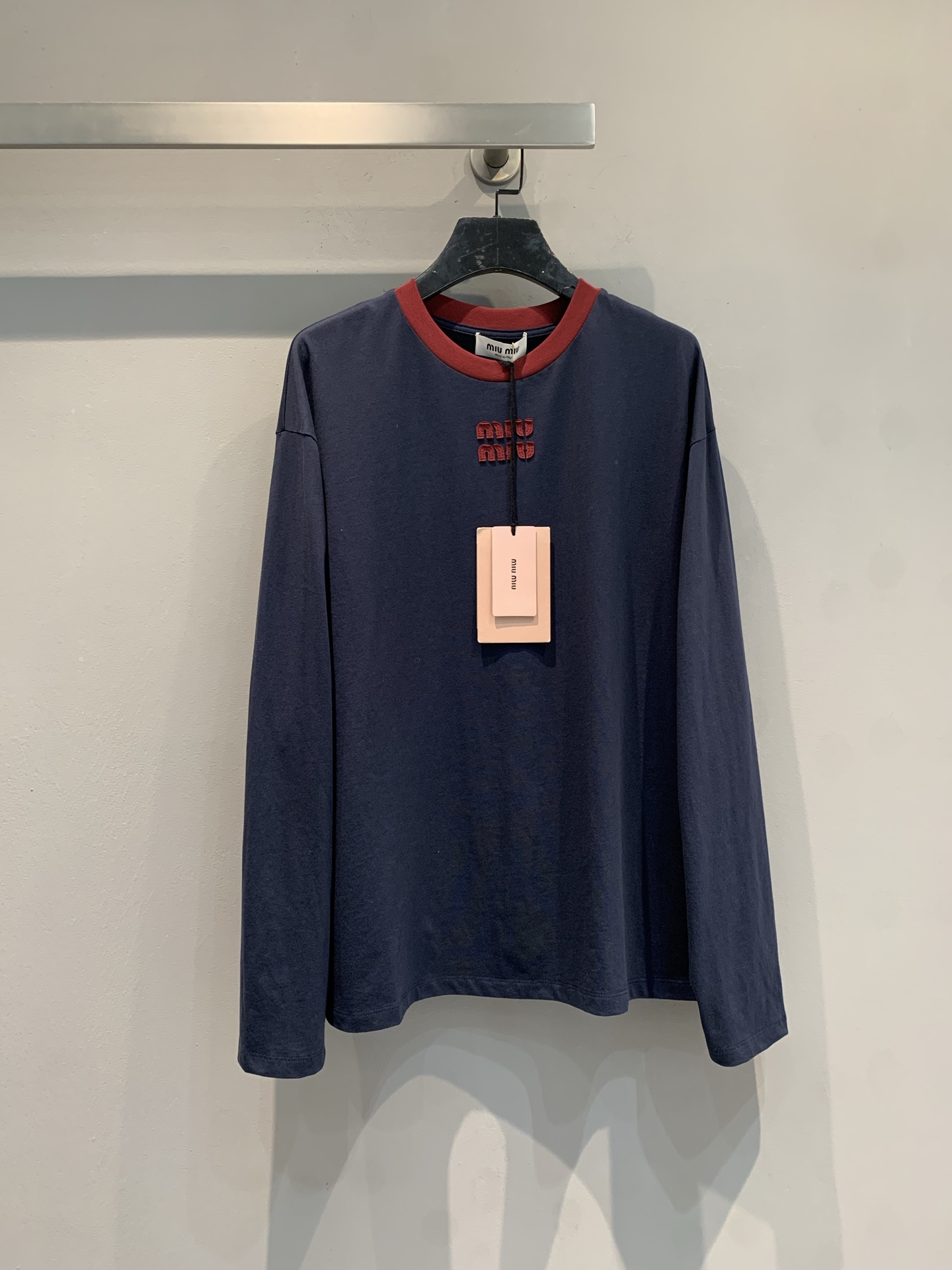 NO:712733,The new model has been shipped. The original developed Miumi* 2026 early spring series navy blue color-blocked long-sleeved T-shirt is made of soft cotton fabric, comfortable and durable, and the loose silhouette is super relaxed. The red logo on the chest + contrasting collar are retro and fashionable, and can be easily used for daily commuting and leisure. Paired with jeans or a pleated skirt, it is simple and detailed, age-reducing and versatile. It is a must-have popular item in early spring!  Size SML,,miumiu,skirts,jeans,tees,t-shirt,19860909新款出货啦 原版开发 Miumi*2026早春系列藏蓝拼色长袖T恤,柔软纯棉面料,舒适耐穿,宽松廓形超显松弛感.胸前红色徽标+撞色领口,复古又时髦,日常通勤、休闲都能轻松驾驭.搭配牛仔裤或百褶裙,简约又有细节,减龄又百搭,是早春必入热门单品！码数SML,,miumiu,skirts,jeans,tees，t-shirt,,Women's clothing