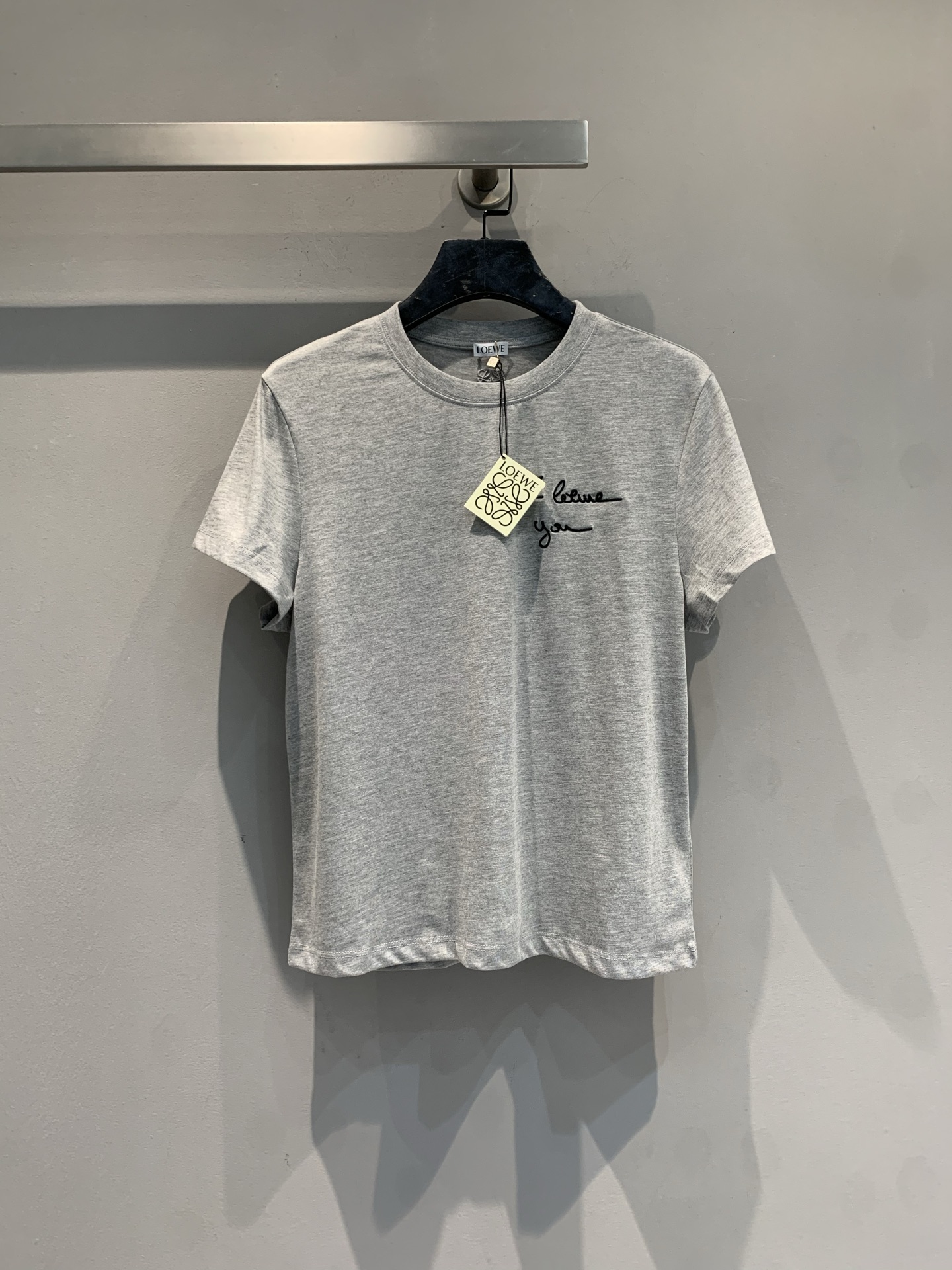NO:728942,The new model is shipped. M original development Loew*2026 spring and summer new simple and versatile gray short-sleeved T-shirt with black handwritten letters printed on the chest 'I love'  you', the design is low-key and a little romantic. The fabric looks like a soft cotton blend with a slightly loose fit, which is suitable for daily commuting, casual outings and other scenarios. When matching, it can highlight the combination idea of 'basic + highlight items' and easily create a high-end outfit. Size SML, loewe, T-shirt, tees, t-shirt,19860909新款出货啦M原版开发 Loew*2026春夏新款简约百搭的灰色短袖T恤,胸前有黑色手写体字母印花“I love you”,设计低调又带点浪漫小心机.面料看起来是柔软的棉质混纺,版型略宽松,适合日常通勤、休闲出街等多种场景.搭配时可突出“基础款+亮点单品”的组合思路,轻松打造高级感穿搭.码数SML,,loewe,T-shirt,tees，t-shirt,,Women's clothing