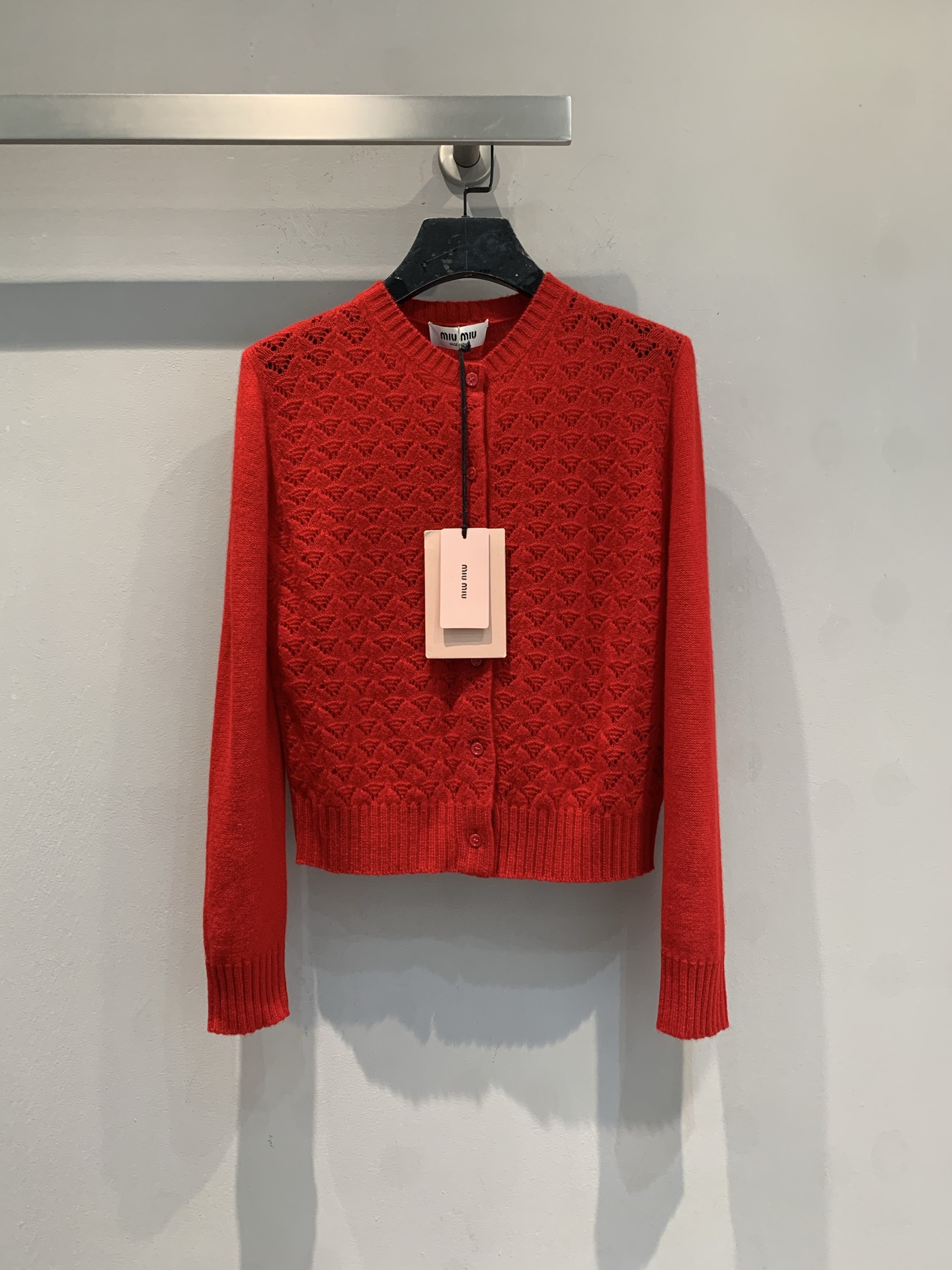 NO:730007,New model shipped, original version developed  Miumi*2026 New Year Red series hollow knitted cardigan adopts a classic V-neck design, with exquisite geometric hollow patterns. The overall texture is delicate and the color is rich and white. It is a tool to create a gentle temperament and French romance in autumn and winter. Whether worn alone or layered, it can easily enhance the layering of the style. It is a short version, which can effectively lengthen the proportion of the legs. It is suitable for matching with high-waisted bottoms to create a taller and slimmer visual effect. Size SML,,miumiu,19860909新款出货啦 原版开发 Miumi*2026新年红系列镂空针织开衫,采用经典V领设计,搭配精致的几何镂空花纹,整体质感细腻,色彩浓郁显白,是秋冬季节打造温柔气质与法式浪漫的利器.无论是单穿还是叠穿,都能轻松提升造型层次感.它属于短款版型,能有效拉长腿部比例,适合搭配高腰下装,打造显高显瘦的视觉效果.码数SML,,miumiu,,Women's clothing