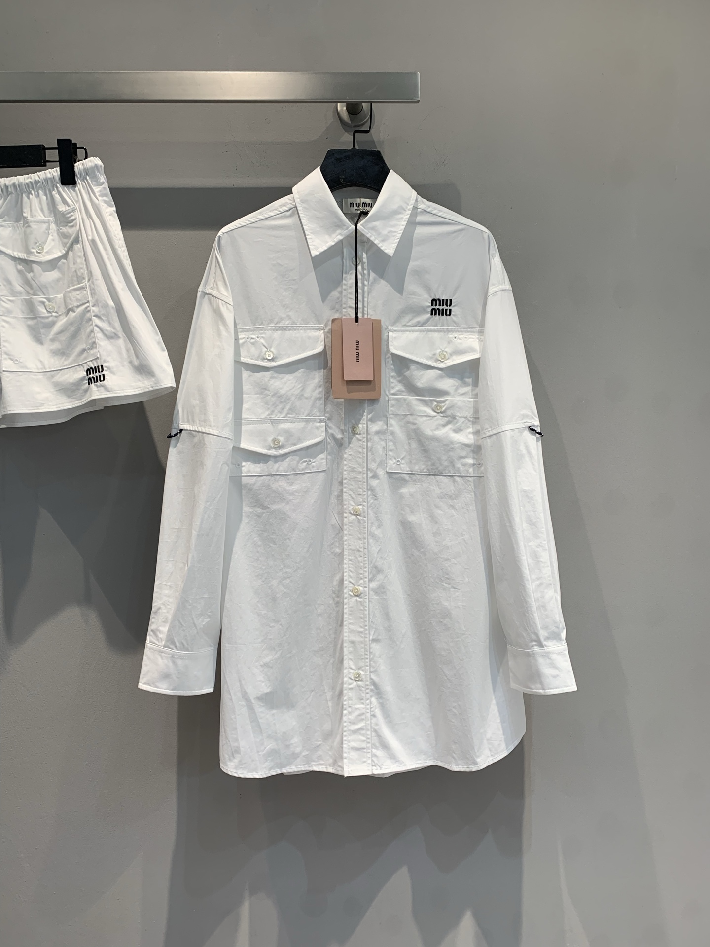 NO:730152,The new model has been shipped. The original development Miumi*2026 early spring new fashionable retro work style long-sleeved shirt has a simple and neat design, with the brand's iconic 'MIU'  'MIU' embroidered logo, double chest pockets + cuff zipper details, both functional and high-end. The fabric is crisp and stylish, suitable for creating clean and neat urban wear, and it is very expressive whether worn alone or layered. The following provides you with multiple practical outfit plans to easily control different occasions. Size SML,, miumiu, shirts,19860909新款出货啦 原版开发 Miumi*2026早春新款时髦复古工装风长袖衬衫,设计简约利落,带有品牌标志性的“MIU MIU”刺绣logo,胸前双口袋+袖口拉链细节,兼具机能感与高级感.面料挺括有型,适合打造干净利落的都市穿搭,无论是单穿还是叠穿都极具表现力.下面为你提供多套实用穿搭方案,轻松驾驭不同场合.码数SML,,miumiu,shirts,,Women's clothing