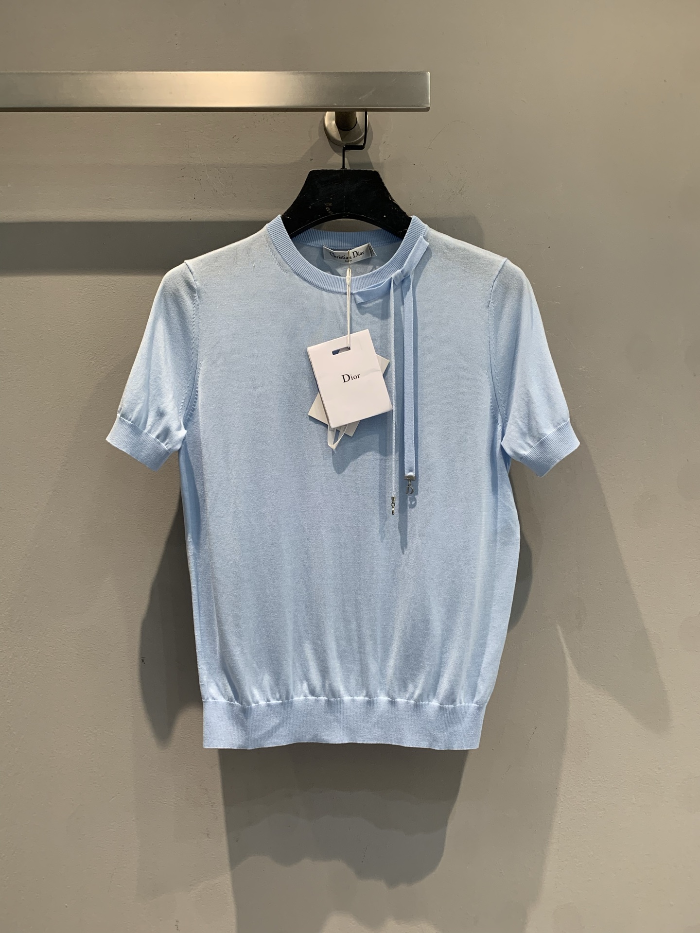 NO:732385,New model shipped, M original development  CD2026 new early spring style fashionable and versatile bow-tie silk knitted short-sleeved top. It is made of fine silk knitted fabric and has a slim fit. It is equipped with an iconic drawstring design at the neckline, which is simple and elegant. The elegant sky blue tone is fresh and gentle, suitable for spring and summer. Whether worn alone or as an inner layer, it can easily enhance the texture of the overall look. The drawstring details not only increase the sense of design, but also adjust the elasticity of the neckline according to preference to create different styles. Size 36 38  40,,T-shirt,real silk,19860909新款出货啦M原版开发 CD2026早春新款时髦百搭蝴蝶结系带真丝针织短袖上衣,采用细腻真丝针织面料,版型修身,领口处配有标志性抽绳设计,简约中透着高级感.淡雅的天蓝色调清新温柔,适合春夏季节穿搭,无论是单穿还是作为内搭,都能轻松提升整体造型的质感.抽绳细节不仅增加了设计感,还能根据喜好调节领口松紧,打造不同风格.码数36 38 40,,T-shirt,real silk,,Women's clothing