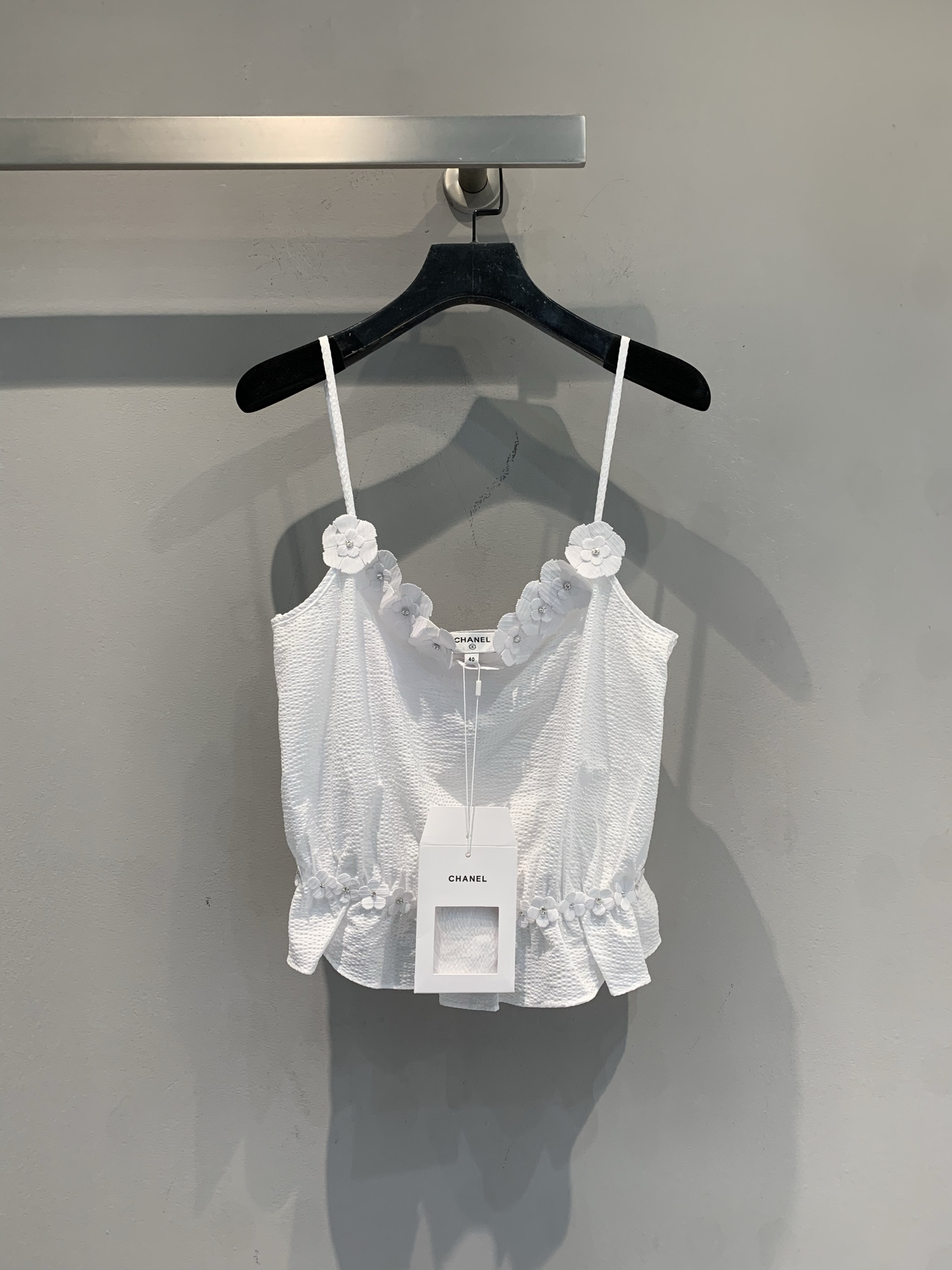 NO:739175,The new model is on the way. Original M development. Camellia beaded sling from C's spring and summer vacation series. Made of white hollow textured fabric, light and breathable, super comfortable to wear in spring and summer!  The neckline and hem are embellished with handmade camellia beading, with exquisite details and perfect elegance. The V-neck + ruffle design modifies the figure and is feminine. It looks great alone or paired with suits and jeans, and can easily switch between multiple styles. Size 36 38 40,,chanel,jeans,business suit,19860909新款出货啦M原版开发 C家春夏度假系列山茶花钉珠吊带,白色镂空肌理面料,轻盈透气,春夏穿超舒服！领口和下摆点缀手工山茶花钉珠,细节精致,优雅满分.V领+荷叶边设计,修饰身形又柔美,单穿或搭配西装、牛仔裤都很出彩,轻松切换多种风格.码数36 38 40,,chanel,jeans,business suit,,Women's clothing