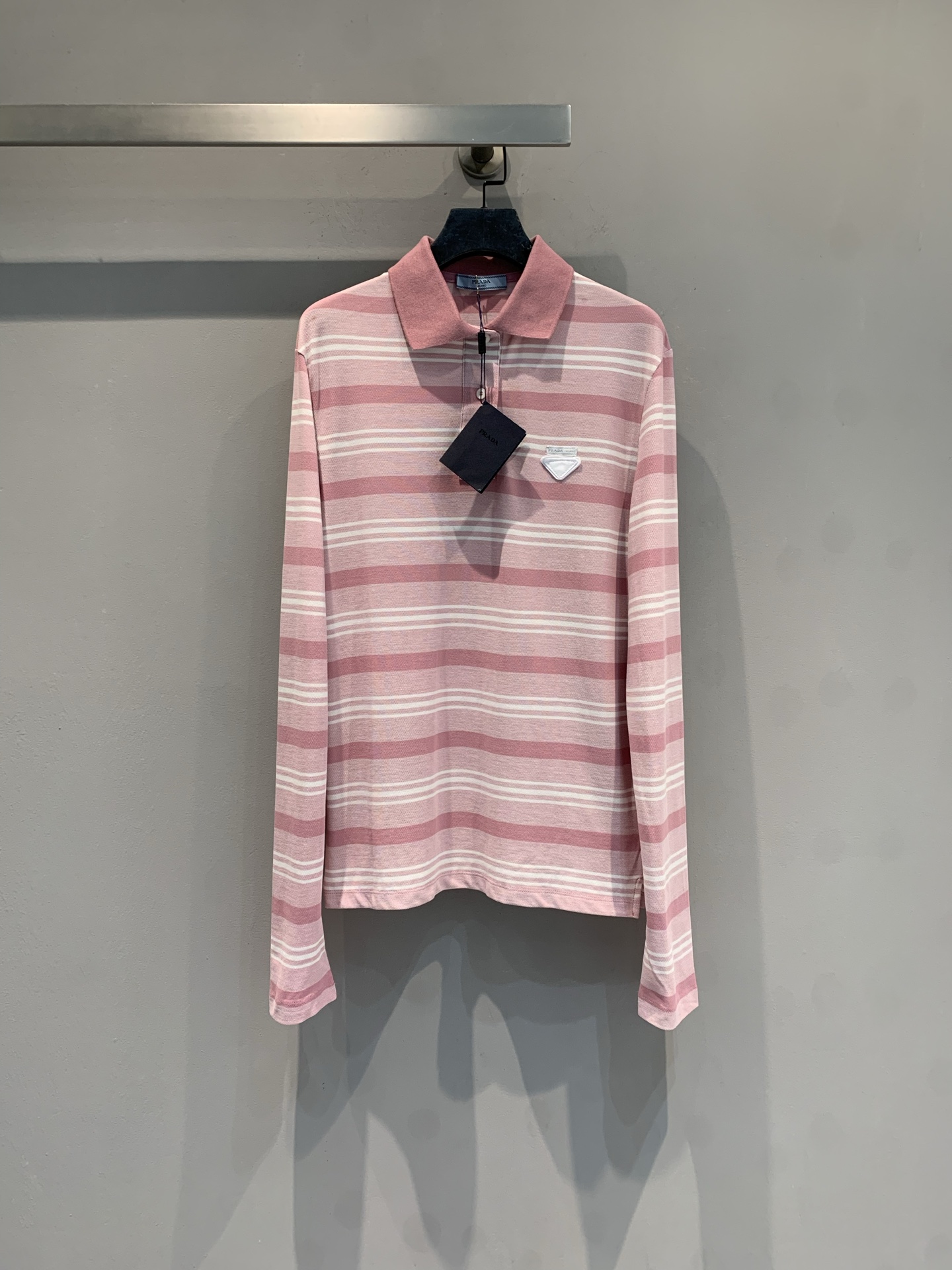 NO:752500,The new model has been shipped. The original Prad* early spring series pink striped long-sleeved polo shirt, pink and white striped design, gentle and retro, soft and comfortable cotton fabric, loose and casual style, can be worn alone or layered. Classic Polo collar + chest brand logo, full of details, easy to control for daily leisure and vacation. Pair it with a skirt or light-colored trousers of the same color, and you can easily get a fresh and fashionable feeling!  Code numberSML,,prada,skirts,19860909新款出货啦 原版开发 Prad*早春系列粉色条纹长袖Polo衫,粉白条纹设计,温柔复古,棉质面料柔软舒适,宽松版型慵懒随性,单穿或叠穿都很OK.经典Polo领+胸前品牌标识,细节满分,日常休闲、度假都能轻松驾驭.搭配同色系半裙或浅色裤装,清新时髦感轻松get！码数SML,,prada,skirts,,Women's clothing