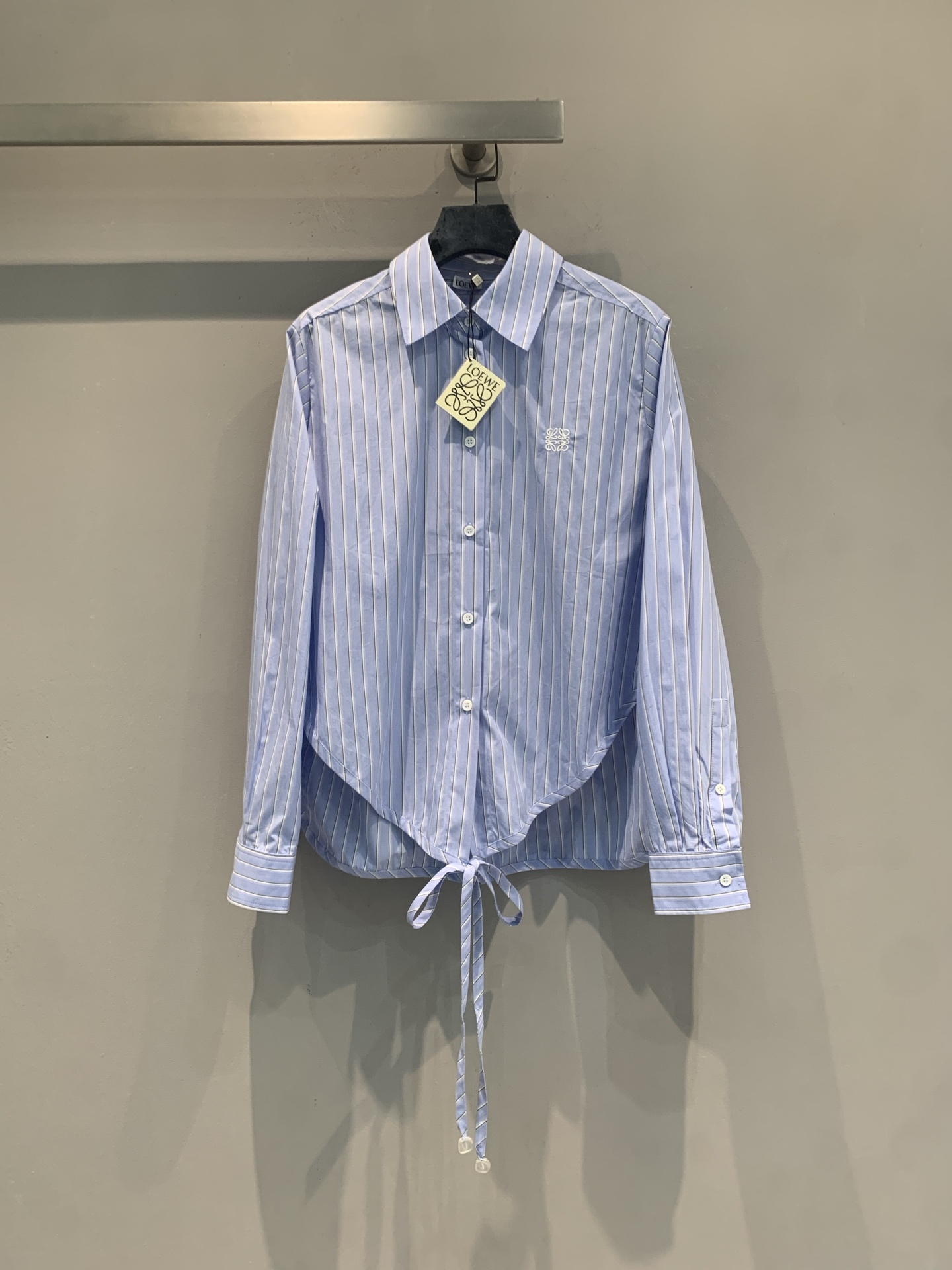 NO:869043,The new model is shipping. Originally developed by Loew*, the new spring and summer fashionable and versatile blue and white striped lace-up shirt is made of light and breathable fabric, perfect for summer wear!  The cross-lace design on the back modifies the waistline and can freely adjust the length of the dress, which is practical and fashionable. The Anagram embroidery on the chest is low-key and exquisite, with perfect details. The blue and white stripes are fresh and simple, which can be easily worn during commuting and vacation. It goes well with jeans or wide-leg pants. It is a must-have and versatile item in the summer wardrobe!  Size SML,,loewe,jeans,shirts,19860909新款出货啦 原版开发 Loew*春夏新款时髦百搭蓝白条纹系带衬衫,轻薄透气面料,超适合夏天穿！背部交叉系带设计,修饰腰线还能自由调节衣长,实用又时髦.胸口Anagram刺绣低调精致,细节满分.蓝白条纹清新简约,通勤、度假都能轻松驾驭,搭配牛仔裤或阔腿裤都很出彩,是夏日衣橱必备百搭单品！码数SML,,loewe,jeans,shirts,,Women's clothing