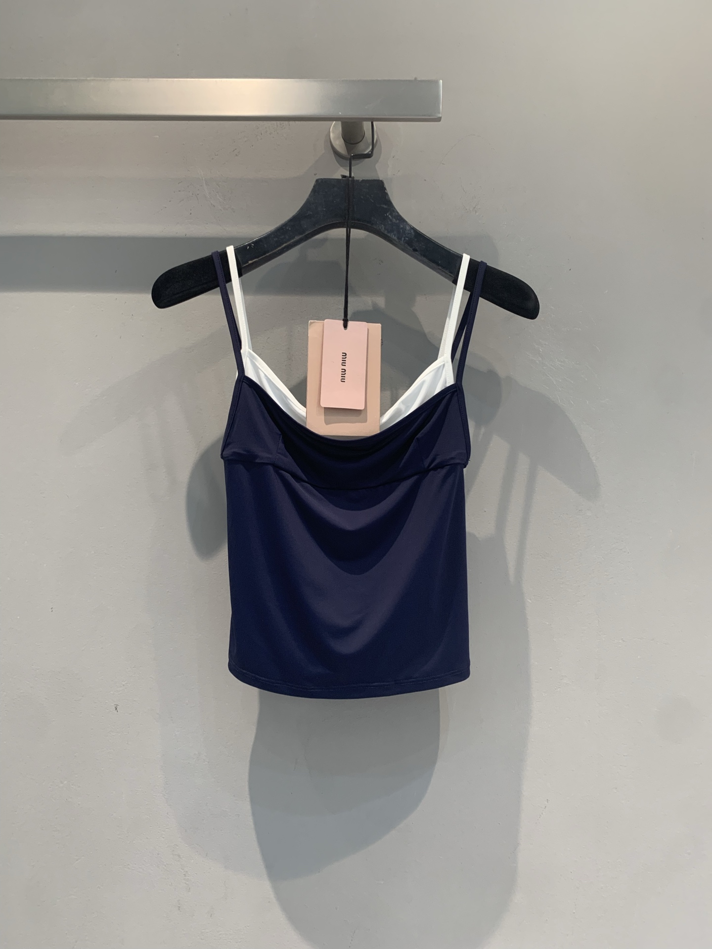 NO:907991,The new model has been shipped. The original developed Miumi* spring and summer new fashionable and versatile fake two-piece camisole, navy blue + white contrasting color design, full of layering, and the layering effect is awesome!  The cotton and ammonia blended fabric is soft and skin-friendly, making it super comfortable to wear in summer without getting sweaty. The slim cut makes you slim, the shoulder straps are slim, and the small logo on the chest is very recognizable. Pair it with jeans, overalls or skirts, and you can easily switch between sweet and cool or casual styles, which is perfect for daily outings and vacations!  Code numberSML,,miumiu,skirts,jeans,19860909新款出货啦 原版开发 Miumi*春夏新款时髦百搭假两件吊带背心,藏青+白色撞色设计,层次感满满,叠穿效果超赞！棉氨混纺面料柔软亲肤,夏天穿超舒服不闷汗.修身剪裁显瘦,肩带细巧,胸前小标超有辨识度.搭配牛仔裤、工装裤或半裙,轻松切换甜酷or休闲风,日常出街、度假都很适合！码数SML,,miumiu,skirts,jeans,,Women's clothing