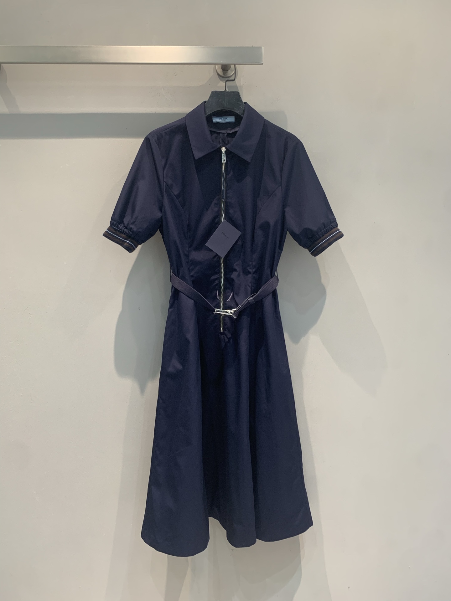NO:906977,The new model has been shipped. The original development of Prad* spring and summer new trendy retro belted navy blue shirt skirt is made of wide cotton fabric, breathable and smooth, super comfortable to wear in summer!  The classic lapel + V-shaped neckline modifies the neck line, making it smart and intellectual. The waist is woven with a metal ring belt to slim down the waist, and the details are perfect!  The skirt is calf-length, formal and casual, and can be easily used for commuting, work, and dating. The navy blue color is low-key, white, and full of elegance. It goes well with small leather shoes or canvas shoes. It is a practical and high-end temperament item!  Size SML,,prada,skirts,shirts,19860909新款出货啦 原版开发 Prad*春夏新款时髦复古腰带藏青色衬衫裙,采用挺阔棉质面料,透气垂顺,夏天穿超舒服！经典翻领+V型领口,修饰颈部线条,干练又知性.腰部编织金属环腰带,收腰显瘦,细节满分！裙长到小腿肚,正式又休闲,通勤、职场、约会都能轻松驾驭.藏青色低调显白,气质感拉满,搭配小皮鞋或帆布鞋都很出彩,是实用又高级的气质单品！码数SML,,prada,skirts,shirts,,Women's clothing