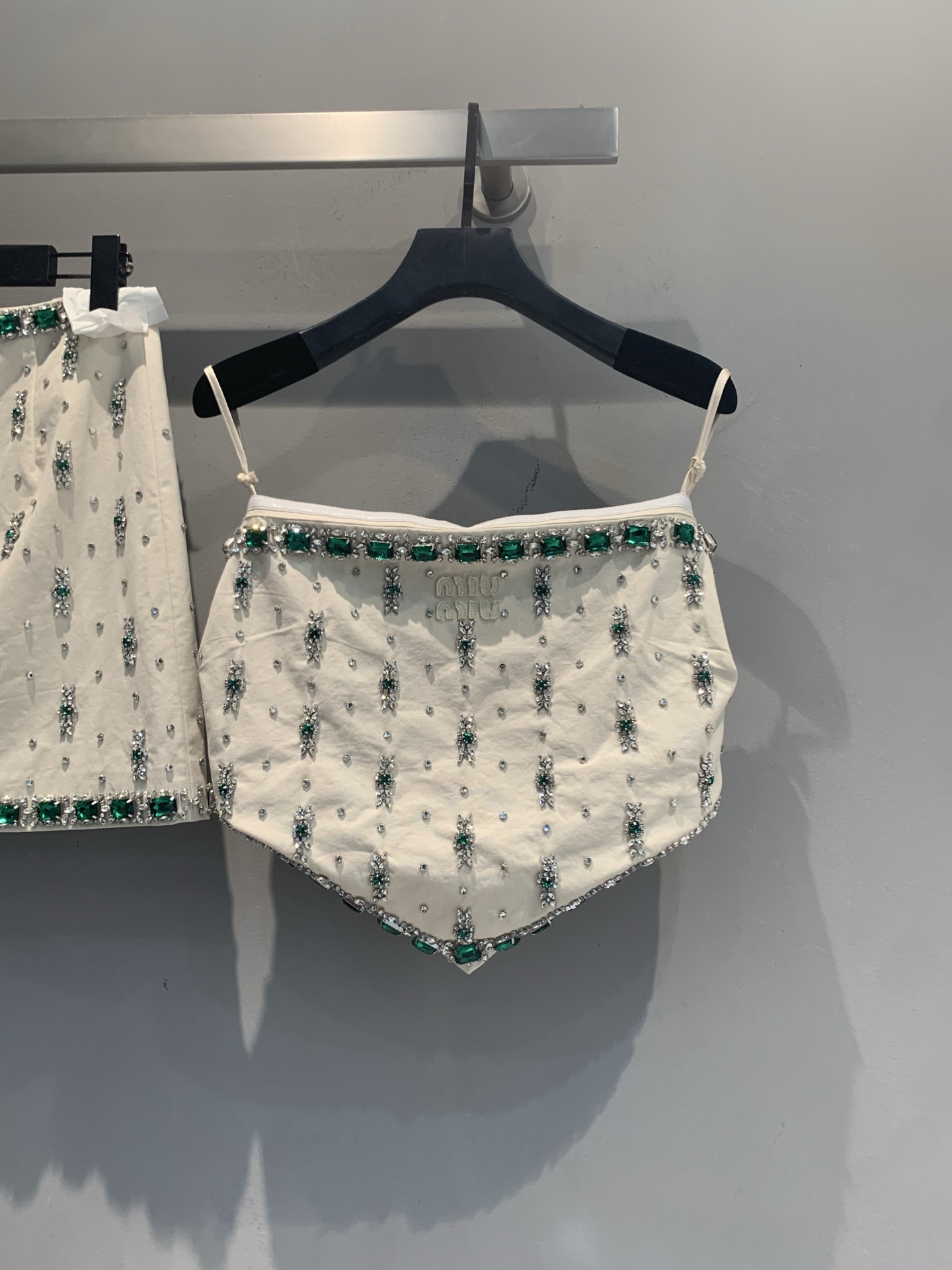 NO:957253,The new tube top is now available, originally developed  Miumi* early autumn new fashionable and versatile heavy-duty emerald tube top skirt set. Off-white high-count cotton base fabric, waist and skirt edges are surrounded by a row of square emerald gems + crushed diamond edging, vertical green diamond flower clusters evenly distributed on the skirt, brand letter logo inlaid with rhinestones on the front, high-waisted A-line version. This set of emerald beading series has a stunning effect on the upper body, and is best worn with the same series of suspenders. Size SML,, miumiu, skirts,19860909新款出货啦抹胸 原版开发 Miumi*早秋新款时髦百搭重工绿宝石抹胸半裙套装.米白色高支棉底布,腰头和裙摆边缘环绕一整排方形祖母绿大宝石+碎钻包边,裙身均匀分布竖向绿钻花簇,正面有水钻镶嵌的品牌字母logo,高腰A字版型.这套绿宝石钉珠系列上身效果很惊艳,搭配同系列吊带成套穿最出片.码数SML,,miumiu,skirts,,Women's clothing