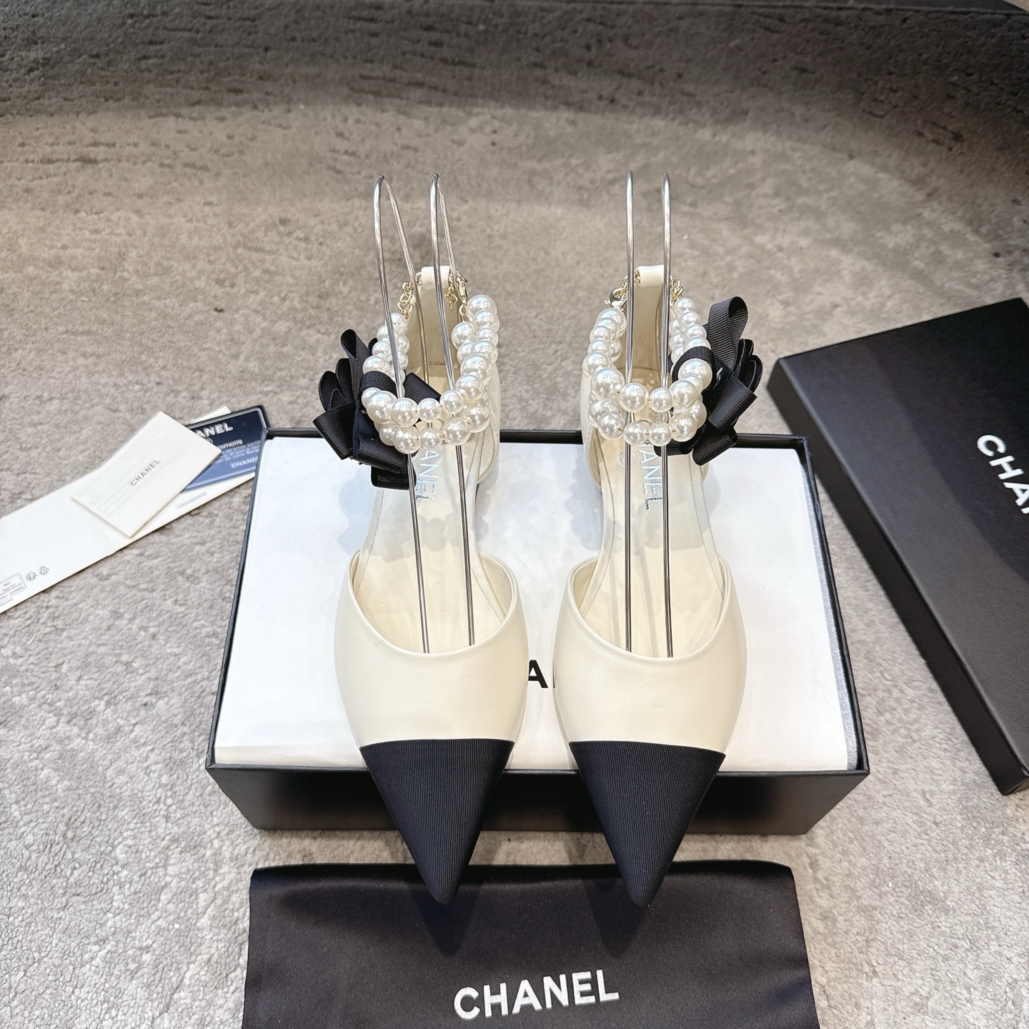 NO:652744,CHANEL 26c Spring and Summer New Style Pointed Toe Anklet Large Pearl Sandals Double C Buckle Camellia Flat Bottom Mary Jane Classic Double Color Blocking Hollow Shoes This sandal opens the beginning of spring and summer with neat tailoring. The color matching design collides with fresh inspiration. The hollow version allows the skin to embrace the breeze freely, and every step is followed by a light rhythm.  .The wide anklet between the ankles is the finishing touch, and the large pearl string trembles with each step, continuing the original intention of small fragrant pearls becoming a feminine element, breaking the boundary between luxury and daily life, so that delicacy does not need to be exaggerated. The pointed design cleverly extends the leg lines, visually elongates the proportion, and easily creates a sense of 'long legs'!  Lambskin upper, sheepskin lining, Italian genuine leather outsole, size 35-39 (40.41 custom-made, non-returnable), sandals, chanel, sandals, mary jane, sheepskin, Leather soles19860909CHANEL 26c春夏新款 尖头脚环大珍珠凉鞋双C扣山茶花平底玛丽珍经典双拼色中空单鞋 这款凉鞋以利落剪裁开启春夏序章,拼色设计碰撞出鲜活灵感,中空版型让肌肤与微风自在相拥,每一步都踩着轻盈韵律 .脚踝间的宽幅脚环是点睛之笔,硕大珍珠串饰随步履轻颤,延续着小香珍珠成为柔美元素的初心,打破华贵与日常的边界 让精致无需浮夸. 尖头设计巧妙延伸腿部线条 视觉上拉长比例 轻松打造“大长腿”既视感！ 鞋面小羊皮 内里垫脚羊皮 鞋底意大利真皮大底 码数35-39（40.41定做不退换）,凉鞋,chanel,sandals,mary jane,sheepskin,Leather soles,Women's Shoes