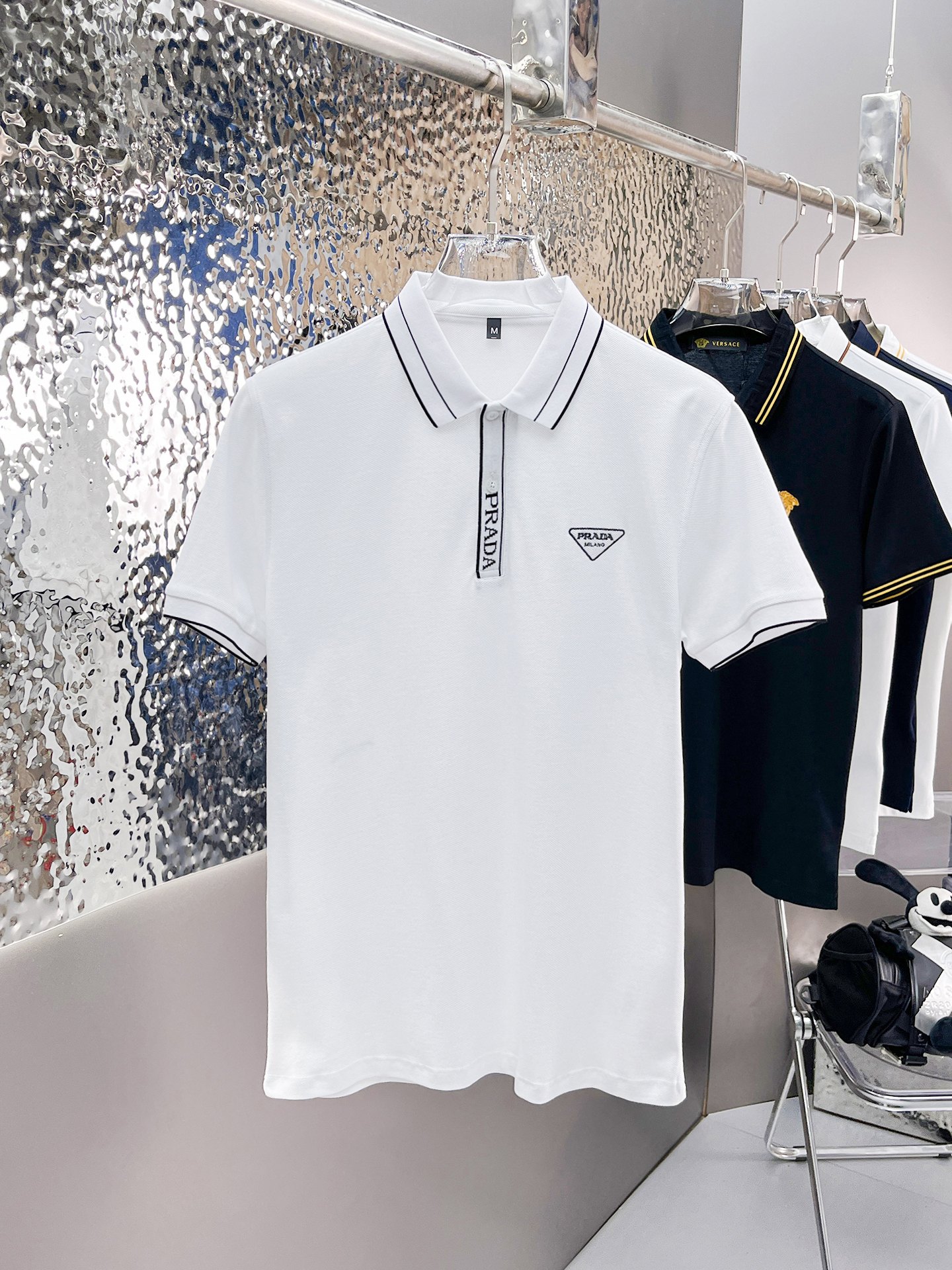 NO:139100,Prada 2025ss summer new letter logo men's lapel Polo shirt!  Classic business men's style, high-end men's style at the ceiling level of business men's style!  Simple, fashionable and elegant, single-wearing inner wear is decent, quality control/detail control takes away, low-key, luxurious and connotative!  Customer-supplied fixed mesh flooring cotton cloth is carefully made, the surface of the fabric is evenly arranged and neatly arranged, with excellent breathability and heat dissipation and sweat resistance, and the comfort level of the upper body is completely better than that of ordinary single-sided sweat cloth tissue!  The classic brand LOGO logo on the chest is created with top-level craftsmanship. The LOGO has three-dimensional, clear and full texture, and is an extraordinary product in the classic field whether it is inner wear or single wear!  The exquisite cutting process, the processing of every detail is very standard and delicate, and it is comparable to that of ordinary LOW products on the market. Men must enter the basic versatile Polo shirts!  Multi-color Size M-3xl, Prada, alexander wang19860909普拉达 2025ss夏季新款字母logo男士翻领Polo衫！经典商务男款,高端男装的天花板级别的商务男款！简约时尚大气不失优雅,单穿内搭体面过人,品质控/细节控的闭眼带走,低调又奢华有内涵！ 客供定织网眼珠地棉布精心制成,面料表面排列均匀整齐的网眼纹理,透气性和散热排汗性极佳,上身舒适程度完全优于普通单面汗布组织！胸前经典的品牌LOGO标识,采用顶级工艺打造,LOGO立体清晰饱满,质感非凡的特质,无论是内搭还是单穿都是一款经典领域的产品！精妙绝伦的裁剪工艺,每一个细节处理的非常标准细腻,非市面一般LOW货可以媲美的,男士必入基础百搭款Polo衫推荐！ 颜色多颜色 尺码M-3xl,,prada,alexander wang,Men's clothing