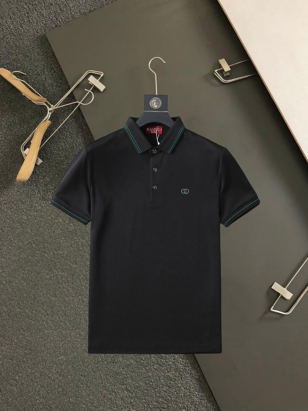 NO:937671,Gucci 2026ss summer new letter logo men's lapel polo shirt!  Classic business men's style, the ceiling-level business men's style of high-end men's clothing!  Simple and fashionable yet elegant, it looks great when worn alone, and the quality/details control can be taken away with your eyes closed. It is low-key, luxurious and connotative!  The custom-woven mesh pique cotton fabric supplied by the customer is carefully made. The mesh texture is evenly arranged on the surface of the fabric. It has excellent breathability and heat dissipation and perspiration. The upper body comfort is completely better than ordinary single-sided jersey tissue!  The classic brand LOGO on the chest is made with top-notch craftsmanship. The LOGO is three-dimensional, clear and full, and has extraordinary texture. Whether it is worn as an inner layer or worn alone, it is a classic product!  The exquisite tailoring process, every detail is handled very standard and delicately, which cannot be compared with other low-end products on the market. It is a must-have basic and versatile Polo shirt for men!  Available in multiple colors, sizes M-4xl,,19860909古奇 2026ss夏季新款字母logo男士翻领Polo衫！经典商务男款,高端男装的天花板级别的商务男款！简约时尚大气不失优雅,单穿内搭体面过人,品质控/细节控的闭眼带走,低调又奢华有内涵！ 客供定织网眼珠地棉布精心制成,面料表面排列均匀整齐的网眼纹理,透气性和散热排汗性极佳,上身舒适程度完全优于普通单面汗布组织！胸前经典的品牌LOGO标识,采用顶级工艺打造,LOGO立体清晰饱满,质感非凡的特质,无论是内搭还是单穿都是一款经典领域的产品！精妙绝伦的裁剪工艺,每一个细节处理的非常标准细腻,非市面一般LOW货可以媲美的,男士必入基础百搭款Polo衫推荐！ 颜色多颜色 尺码M-4xl,,,Men's clothing