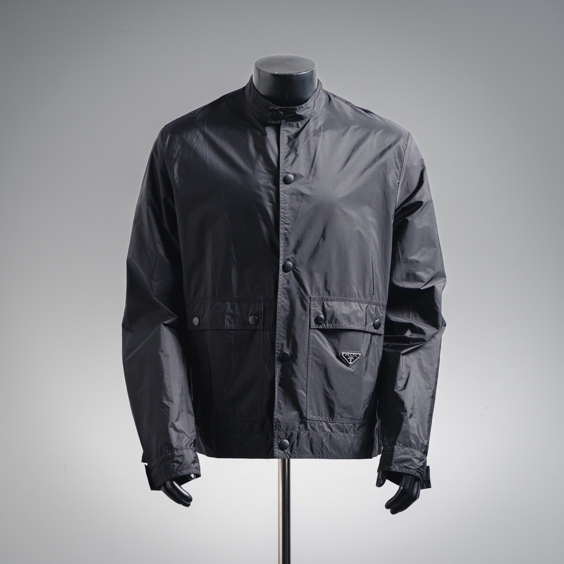 NO:954757,Ready stock, fully repaired, full-year after-sales service PRADA PRD flap pocket concealed button regenerated nylon stand-up collar jacket  The brand's iconic regenerated nylon fabric is selected, which has the same performance as traditional nylon and has high strength, tear resistance, abrasion resistance and other properties. It is light in texture and has waterproof function suitable for many scene needs. It is anti-wrinkle and quick-drying and is easy for daily care and maintenance. The unlined single-layer structure relies on the high-density weaving characteristics of regenerated nylon to make it both breathable and protective. It adopts a stand-up collar structure to fit the neck line and take into account windproof function and dryness.  It has a refined temperament. The two sides are equipped with extra large-capacity flap pockets to enhance practicality with a three-dimensional structure. The inner hidden pocket design enhances the private storage experience. The lid and bag body are wrapped and reinforced with double-needle stitching technology. An enamel-coated triangle logo is decorated on one side of the bag body to enhance visual recognition. The combination of cuff straps and concealed buckles achieves precise elasticity requirements. The straight bottom edge structure of the front hem and the flat ribs at the rear make it both beautiful and practical. Customized accessories  Size:M~3XL,,prada,prada,jackets & coats,jackets & coats,19860909现货精修 全年售后 PRADA普拉达PRD 翻盖口袋暗扣再生尼龙立领夹克外套 选用品牌标志性的再生尼龙面料,与传统尼龙性能相当,具备高强度,抗撕裂,耐磨损等特性.其质地轻盈,同时又具备防水功能适合多场景需求.抗皱,快干的特点也易于日常打理维护.无衬里单层结构,依托再生尼龙的高密度编织特性,使其透气性与防护性并存.采用立领结构,贴合颈部线条,兼顾防风功能和干练气质.两侧搭配超大容量翻盖口袋,以立体结构强化实用性,内层暗袋设计提升私密收纳体验,盖体和袋体均用双针车线工艺进行包边加固,将涂珐琅三角标饰以一侧袋体之上,强化视觉辨识度.袖口袢带与暗扣的组合实现精准松紧需求,下摆正面平直底边结构与后方的扁牛筋收口让其兼顾美感和实用性.定制辅料 Size:M~3XL,,prada,prada,jackets & coats,jackets & coats,,Men's clothing