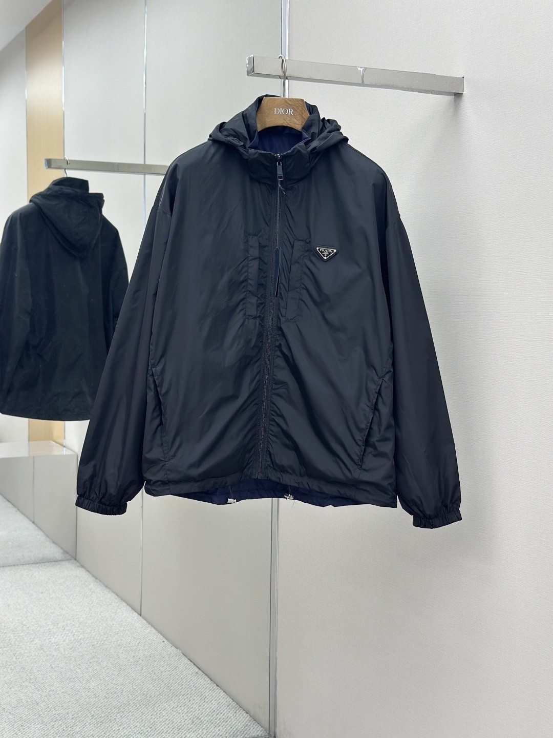 NO:936861,PRADA regenerated nylon reversible jacket fabric selection uses the brand's iconic regenerated nylon fabric, which has the same performance as traditional nylon and has high strength, tear resistance, abrasion resistance and other properties. Its texture is light and waterproof, suitable for multiple scene needs. It is anti-wrinkle and quick-drying and is easy to care for and maintain on a daily basis. Technology  Wrap the parts with bias-cut fabric strips, and control the width to about 0.4CM. Align the edges of the two layers of fabric, fold and sew, and hide the seams in the interlayer. Then fix it with the 'anchor point'. There will be no burrs on both the inner and outer sides, and all seams will be completely wrapped, while preventing the bad experience of easy relative sliding during wearing. Accessories Customized triangle label Customized hem elastic buckle Customized hat rope elastic leather head Customized zipper puller SIZE: M~3XL,, prada, jackets & coats, hats,19860909PRADA再生尼龙双面穿夹克 面料选择 选用品牌标志性的再生尼龙面料,与传统尼龙性能相当,具备高强度,抗撕裂,耐磨损等特性.其质地轻盈,同时又具备防水功能适合多场景需求.抗皱,快干的特点也易于日常打理维护. 工艺 用斜裁布条包裹份,宽度控制在0.4CM左右.将两层面料边缘对齐后折叠缝合,缝线隐藏于夹层.再通过“锚定点”固定.形成内外两面均无毛边,所有缝份完全包裹,同时防止穿着中易相对滑动的不良体验. 辅料定制三角标  定制下摆松紧扣  定制帽绳松紧皮头  定制拉链头 SIZE: M~3XL,,prada,jackets & coats,hats,,Men's clothing