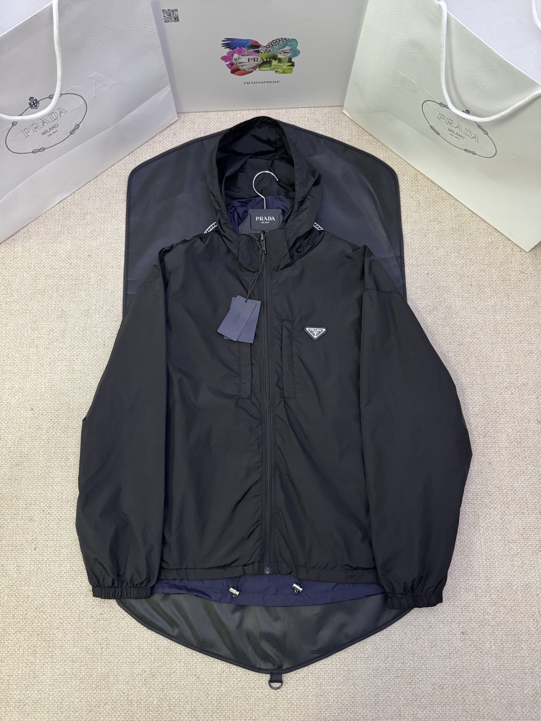 NO:869271,NL exclusive original developed PRADA regenerated nylon double-sided jacket  Craftsmanship description Made of environmentally friendly recycled fabrics, reflecting the brand's commitment to sustainable development. The jacket has a reversible design and is decorated with the iconic enameled triangle metal logo on the front, highlighting the brand's DNA. The oversize silhouette is paired with a wide shoulder design to create a fashion-forward visual effect. The straight sleeves are equipped with elastic cuffs to ensure wearing comfort. The hood stand-up collar design is combined with an elastic drawstring to provide windproof protection  Warm function. The zipper opening and closing system is equipped with invisible zipper pockets, taking both practicality and aesthetics into consideration. The elastic bottom edge design makes the overall silhouette more three-dimensional and stylish. In order to maintain the fabric characteristics and reduce environmental impact, it is recommended to reduce the frequency of washing, dry it naturally after use, and choose professional environmentally friendly dry cleaning services. This jacket perfectly integrates practical functions with fashion aesthetics, demonstrating PRADA's dual pursuit of craftsmanship quality and environmental protection concepts.  Color Black Size M-3XL,,prada,versace,jackets & coats,jackets & coats,hats,19860909NL独家原版开发PRADA再生尼龙双面穿夹克外套 工艺说明采用环保再生面料制成,体现了品牌对可持续发展的承诺.夹克采用双面可穿设计,正面饰有标志性涂珐琅三角形金属徽标,彰显品牌基因.oversize廓形搭配宽肩设计,营造时尚前卫的视觉效果.直筒衣袖配以弹力袖口,确保穿着舒适度.风帽立领设计与弹力抽绳相结合,提供防风保暖功能.拉链开合系统搭配隐形拉链口袋,兼顾实用性与美观度.弹力底边设计使整体廓形更加立体有型.为保持面料特性并减少环境影响,建议减少清洗频率,使用后自然晾干,并选择专业环保干洗服务.这款夹克将实用功能与时尚美学完美融合,展现了PRADA对工艺品质与环保理念的双重追求. 颜色黑色 尺码M-3XL,,prada,versace,jackets & coats,jackets & coats,hats,,Men's clothing