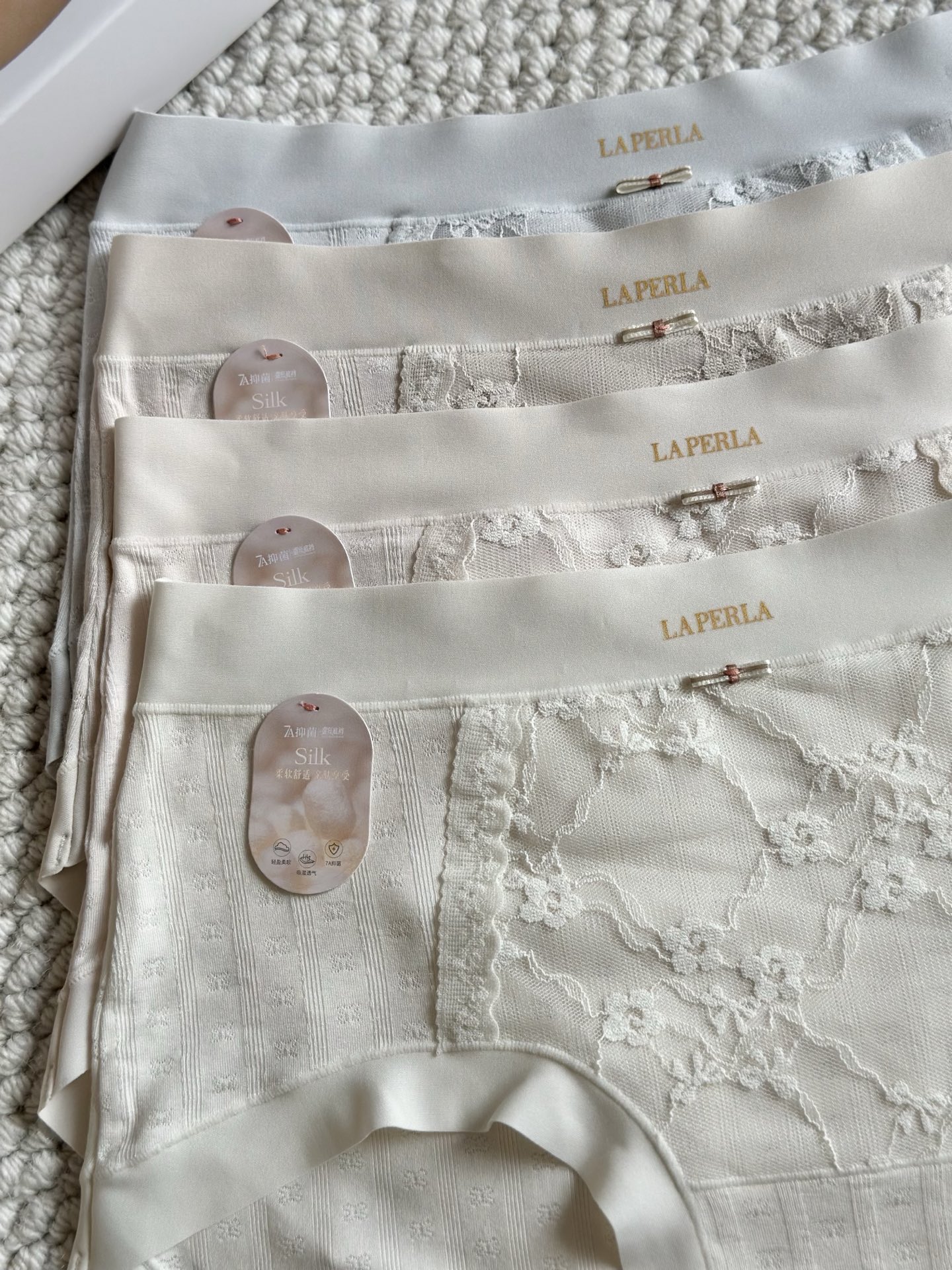 LaPerla莫代乐蕾丝拼接内裤，女性专属呵护材质: 这是一张衣物洗唛的图片，展示了以下信息：货号: •