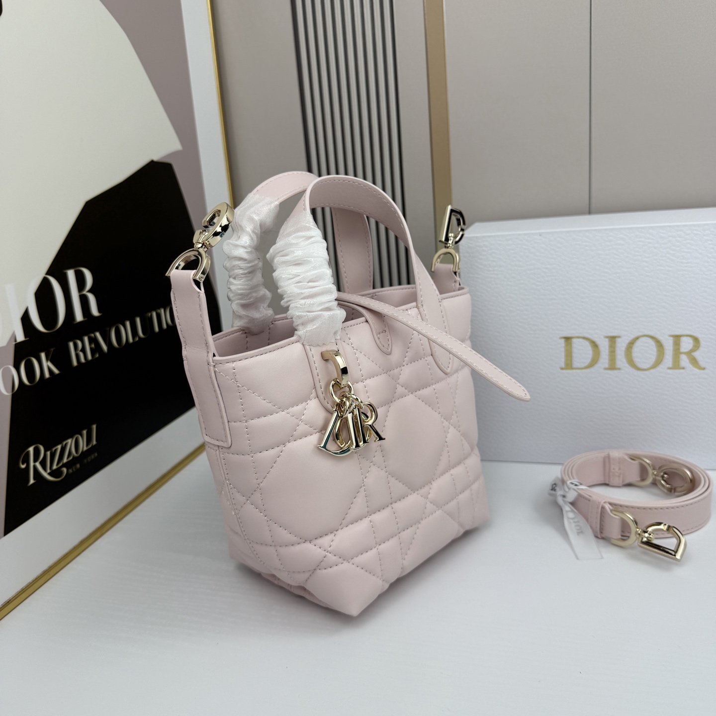 miniDior Toujours 竖版手袋时尚实用，别具一格。采用胭脂米色牛皮革精心制作，饰以超大藤格