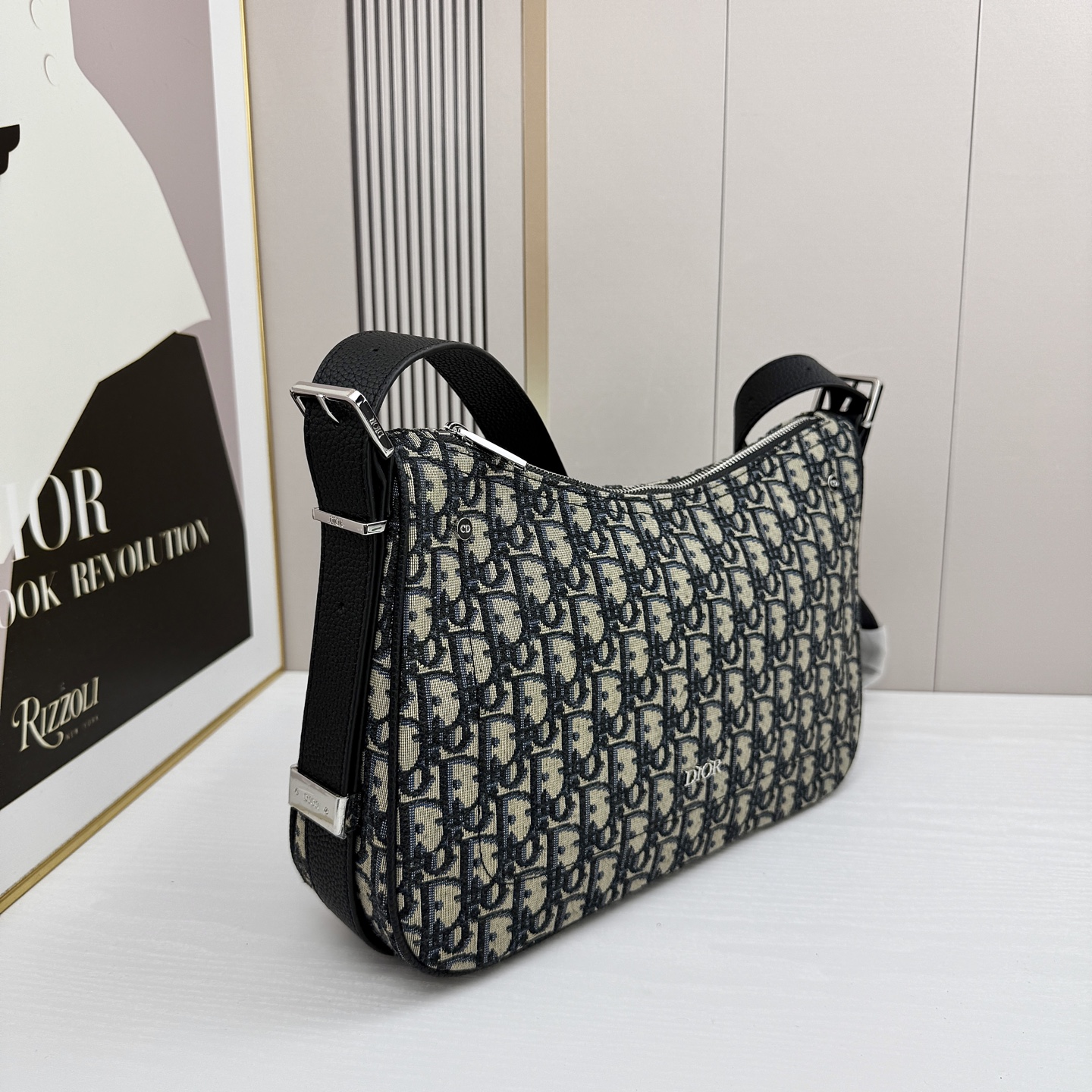 这款 Dior Slider 拉链水饺包是二零二五冬季男装系列新品，高雅时尚。廓形简约柔软，采用黑色 O