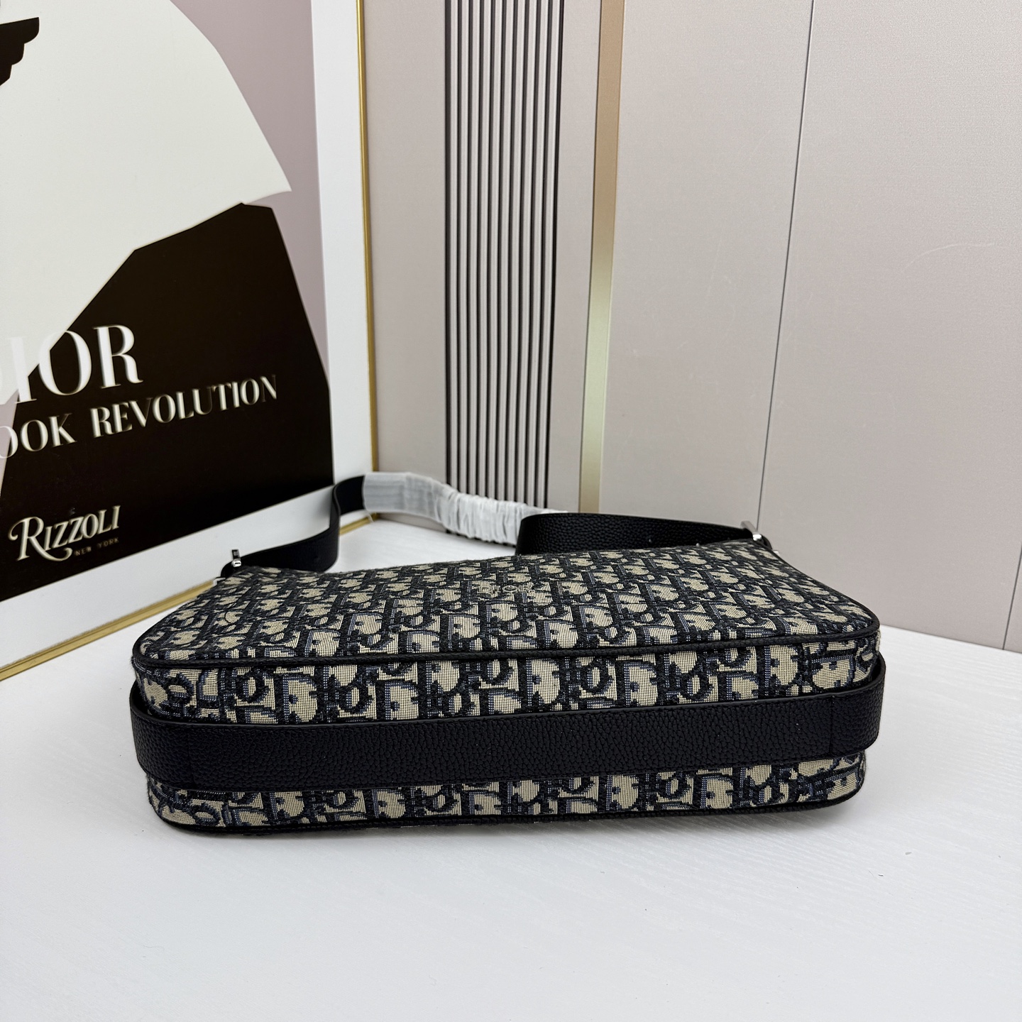 这款 Dior Slider 拉链水饺包是二零二五冬季男装系列新品，高雅时尚。廓形简约柔软，采用黑色 O