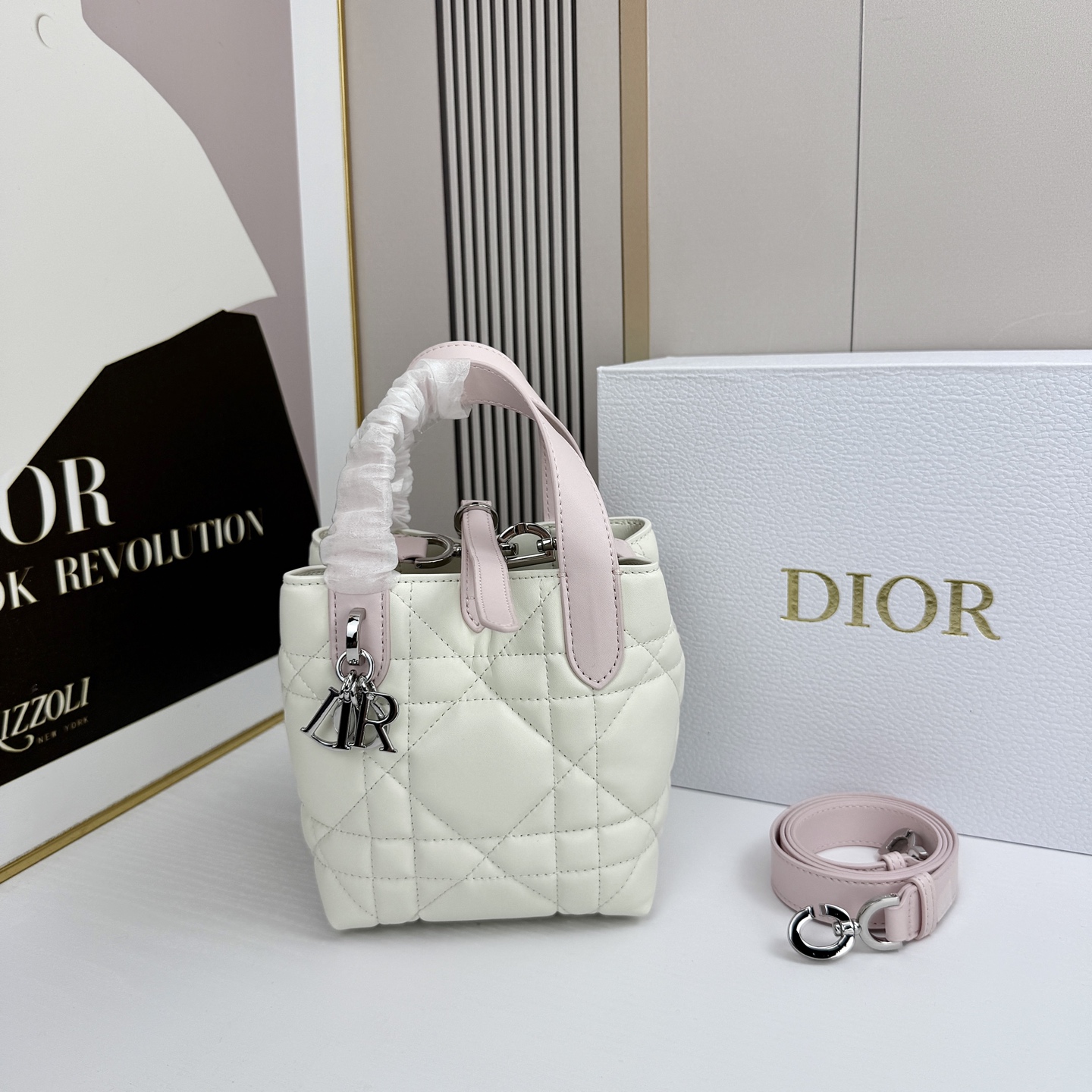 miniDior Toujours 竖版手袋时尚实用，别具一格。采用胭脂米色牛皮革精心制作，饰以超大藤格