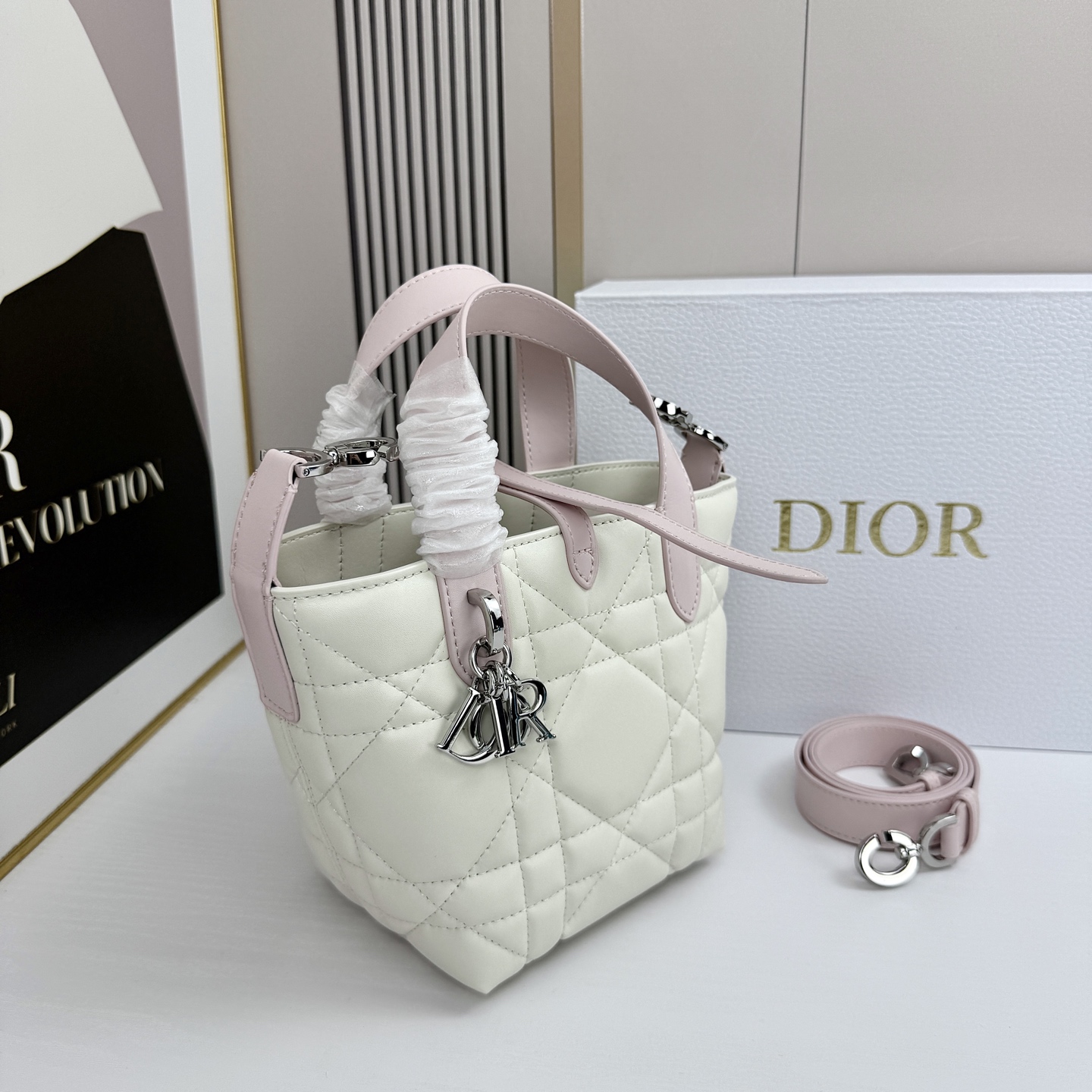 miniDior Toujours 竖版手袋时尚实用，别具一格。采用胭脂米色牛皮革精心制作，饰以超大藤格
